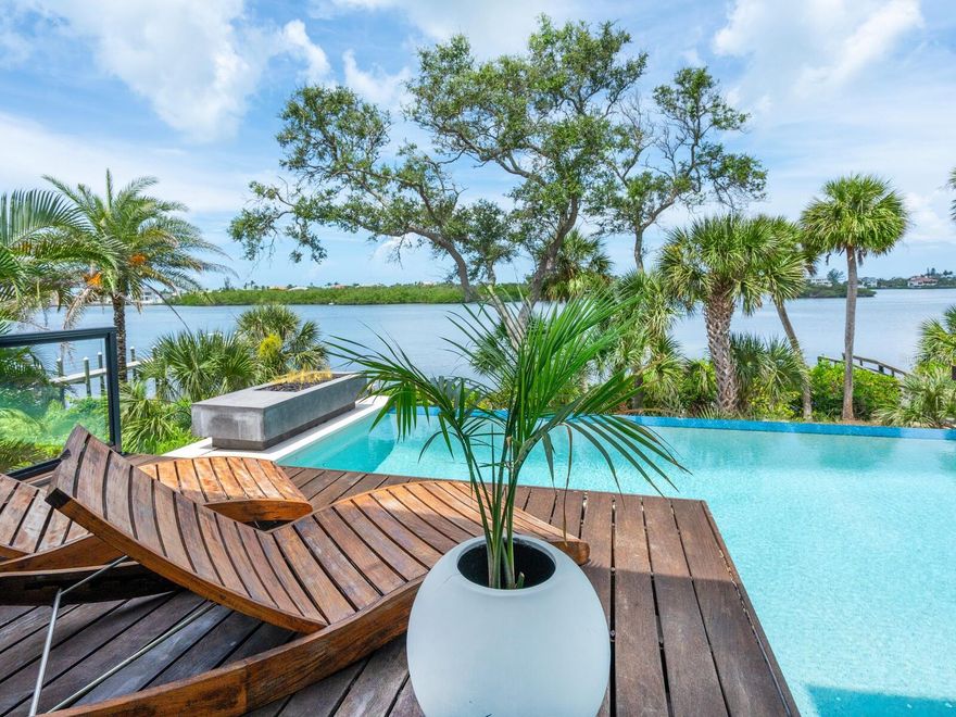 Discover an extraordinary, bayfront contemporary masterpiece in the exclusive Blackburn Estates, a gated enclave of serenity. This five-bedroom, seven-bath residence redefines luxury, with a harmonious blend of sleek modern design and timeless craftsmanship. Among this home's many unique features is an indoor basketball half-court, above the three-car garage! Go through the bespoke solid walnut pivot door into a world of elegance, where panoramic bay views captivate instantly. The great room exudes warmth and sophistication, with its soaring wood-paneled ceilings, custom recessed and pendant lighting, and polished charcoal-stained slab floors. A striking 10-foot ledgestone fireplace anchors the space, seamlessly connecting to an expansive outdoor oasis via pocketed sliding glass doors. Outside, a disappearing-edge pool with ice deck steppingstones and sun shelf, complements a vast patio and outdoor kitchen, ideal for entertaining or tranquil relaxation. This architectural gem effortlessly combines low maintenance luxury with family-friendly functionality, at the end of a peaceful cul-de-sac. A rare opportunity to own a home that is a sanctuary and a statement.