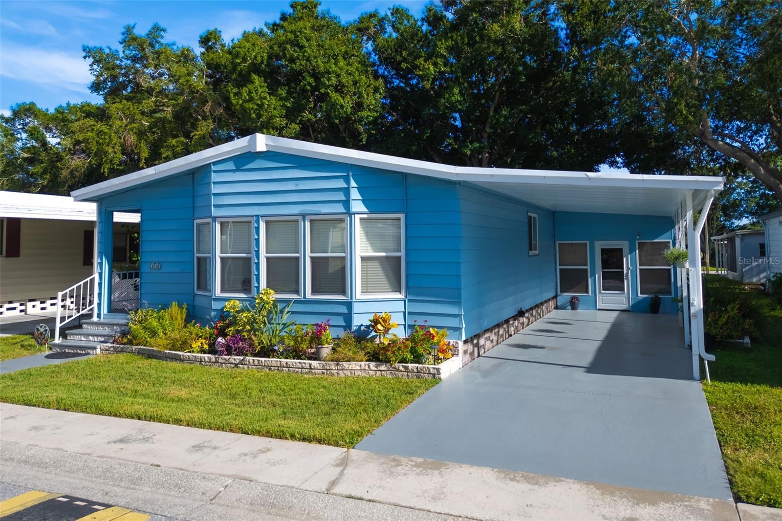 Welcome home to this fully remodeled 3 bedroom, 2 bathroom home in Paradise Island, an exquisite 55+ community. This mobile home offers an abundance of space and convenient amenities designed for comfortable living. Step inside the open floor plan that flows through the spacious living area, kitchen, and dinning area with top of the line Life Proof Laminate floors throughout. The gourmet kitchen offers updated cabinets, quartz counters, and stainless steel appliances. Three generously sized bedrooms provide the perfect space for privacy and relaxation or the use for a private office. The primary suite features a large walk-in closet, dual vanities, and shower. Indoor new washer/dryer room with extra storage. Step out through your sliding glass doors to the fully enclosed Lani with a large storage shed off the back. Extra large carport for all your parking needs. This home has tons of upgrades including, new roof in 2020, fully repainted with updated ceiling, landscaping, PGT windows, freshly painted carport and front porch, flooring and much more. Paradise Island has a beautiful in-ground pool/spa and plenty of activities within this community ranging from bingo, karaoke, shuffleboard, pool, dancing, garage sales and even talent shows. There's a library with books, puzzles, games and magazines. The famous Florida beaches are only minutes away and Tampa is 30 minutes. Call today for your showing. Price of home includes owning the share for land. Can be sold separately. Furniture can sold separately.
