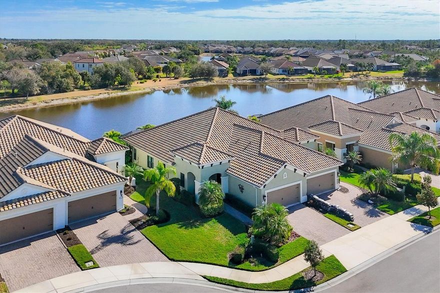 This meticulously designed villa presents an exceptional opportunity for discerning buyers. The residence offers captivating water views and an eastern-facing lanai, ideal for experiencing tranquil morning sunrises. The expansive open-concept floor plan seamlessly integrates three bedrooms, two bathrooms, and a dedicated study, accessible via elegant glass French doors, balancing comfort with practical utility. Upon entry, one immediately appreciates the profound attention to detail evident in the custom window treatments, designer lighting fixtures, and ceiling fans thoughtfully installed throughout. Notable enhancements include tray ceilings with sophisticated crown molding, substantial 8-foot interior doors, and a remodeled guest bedroom featuring custom shiplap. Rich hickory wood floors extend uniformly across the primary living areas, contributing to the home's refined aesthetic. The gourmet kitchen is appointed with gleaming granite countertops, stylish deco-trim full overlay Maple Dovetail cabinets, and a central island equipped with under-cabinet mood lighting and soft-close doors and drawers. A tasteful tile backsplash, newly upgraded appliances—including a dishwasher and refrigerator acquired within the last two months and accompanied by extended warranties—a natural gas range, and a spacious closet pantry complete this culinary haven. The owner's suite serves as a private retreat, featuring two walk-in closets, dual vanities with granite countertops, and a luxurious walk-in shower. Outdoors, an extended lanai with pavers and a screened patio provides an exquisite setting for both relaxation and entertaining. The property's curb appeal is further elevated by charming coach lighting, a comprehensive new landscape design with drip irrigation, two stately Christmas Palms, and a paver driveway, walkway, and front patio. This exceptional villa also benefits from a whole-house water filtration and softener system, ensuring premium quality and comfort. Strategically situated on a serene cul-de-sac and proximate to the neighborhood pool, this home is perfectly suited for seasonal retreats or year-round residency. Located within the amenity-rich Grand Palm community, residents enjoy convenient access to historic downtown Venice, pristine beaches, diverse dining establishments, and various other attractions. This highly sought-after community boasts a full-time activity coordinator, a well-appointed clubhouse, a fitness center, tennis courts, pickleball facilities, multiple community pools, and miles of scenic walking and biking trails. We invite you to schedule a private showing to experience the distinguished lifestyle afforded by this remarkable property.