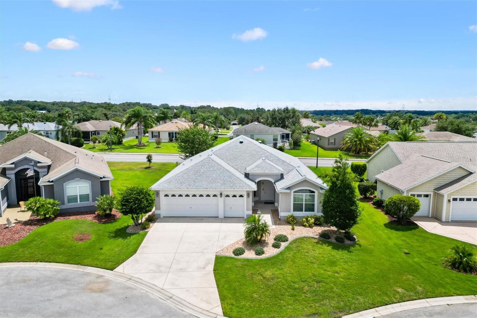One or more photo(s) has been virtually staged. BOND IS PAID on this Beautiful Begonia Model in the Highly Sought-After VILLAGE OF AMELIA! This meticulously maintained 3 Bedroom, 2 Bathroom home with a 2-CAR GARAGE plus a GOLF CART GARAGE sits on a quiet CUL-DE-SAC. Located just 3 miles from the popular LAKE SUMTER LANDING Square where you can Dine, Shop, see a Movie and enjoy the Nightly entertainment on the Square. There is NO CARPET here. You will Enjoy brand-new LUXURY VINYL PLANK FLOORING in the Living Room, Dining Room and Bedrooms and diagonally laid tile in the Kitchen, Nook and Bathrooms. The open-concept of this home connects the Living Room, Dining Room and Kitchen creating a spacious and inviting living area which is Perfect for Entertaining.
The Kitchen features stainless steel appliances, pull-out shelves in lower cabinets, pot drawers, a pantry with pull out shelves and a cozy eat-in nook and bar. The Glass-Enclosed Lanai offers year-round enjoyment with privacy window tinting and electric privacy shades and provides an additional 308 SF of Living space. The Primary Bathroom includes a ROMAN WALK-IN SHOWER, commode closet and dual vanity sinks. The Primary Suite is thoughtfully separated from the Guest Bedrooms and Guest Bathroom which features a tile-surround tub with glass doors. Perfect for your visiting guests!
Additional highlights: ROOF and HVAC (2022), new interior paint, updated light fixtures, 2 solar tubes, upgraded landscaping, and lightning rods for added peace of mind. Did I say the BOND IS PAID? Don’t miss this move-in-ready gem in a prime Villages location! Call me today for a private showing.