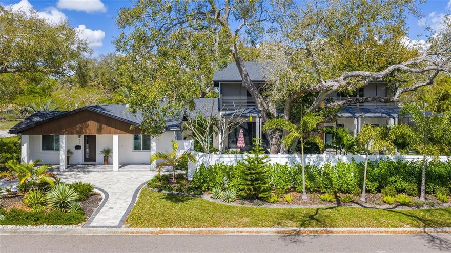 You haven’t found paradise until you step inside 639 43rd Avenue North in St. Petersburg. Located in the peaceful and coveted Allendale Terrace neighborhood, just five minutes from vibrant downtown St. Petersburg and only 15 minutes from the beaches, this extraordinary multi-generational estate offers luxury, privacy, and thoughtful design throughout. The original home was completely remodeled in 2021, blending timeless character with modern elegance. As you arrive via the enchanting circular walkway and enter the original residence, you’re welcomed into a spacious, fully updated kitchen and living room designed for comfort and entertaining. Two bedrooms are positioned to the right, ideal for guests or family members. Beyond the kitchen sits an oversized laundry room, and across from it, a stunning master retreat featuring a fully remodeled custom-tiled bathroom and oversized bedroom with a private sitting area — a peaceful escape within the home. The original home and new addition are connected by an enclosed breezeway with French doors providing entrances to both the north and south sides of the property. Passing through the breezeway, you enter the new 2,821 square foot addition completed in August 2024. This space feels like a brand-new home featuring a gorgeous modern kitchen within the breathtaking 820 square foot great room, perfect for entertaining gatherings of any size. Large multi-panel sliding glass doors open to the 1,500 square foot lanai and pool area. The oasis-style pool and lanai, completed in September 2024, create a resort-like experience in your own backyard. The 30 ft by 14 ft heated pool is accented with blue iridescent tile and complemented by a separate hot tub area, surrounded by lush tropical landscaping, palm trees, and mature oaks offering privacy and serenity. A striking staircase with contemporary chandelier and metal railing leads upstairs to a thoughtfully designed split floor plan featuring two expansive master suites positioned on opposite sides for maximum privacy. Each suite is approximately 650 square feet and includes a large bedroom, additional living space ideal for an office or lounge, a full custom-tiled bathroom, generous walk-in closet, and screened-in balcony — perfect for morning coffee or evening cocktails. In total, the home offers 4,518 square feet of air-conditioned space with five bedrooms, three of which are true master suites, five full custom-tiled bathrooms, and two full kitchens — ideal for multi-generational living while maintaining privacy. There are two laundry rooms, including one with an oversized washer and dryer for convenience. Water quality is maintained by a water filtration and reverse osmosis system. The home also features a large attached two-car garage with an “oatmeal” pattern epoxy floor and a separate garden utility shed for additional storage. Situated on a double lot totaling 12,197 square feet, the property is surrounded by lush tropical landscaping and a lock-enabled fence for privacy and security. A seven-zone Rain Bird irrigation system with an on-site deep well maintains the grounds year-round. The entire home received a brand-new roof in January 2024, and all windows and exterior doors are storm-resistant and code compliant. No flood insurance is required as the property is located in a minimal risk flood zone. This is more than just a home — it’s a private compound designed with vision and style. With space, sophistication, and location working in harmony