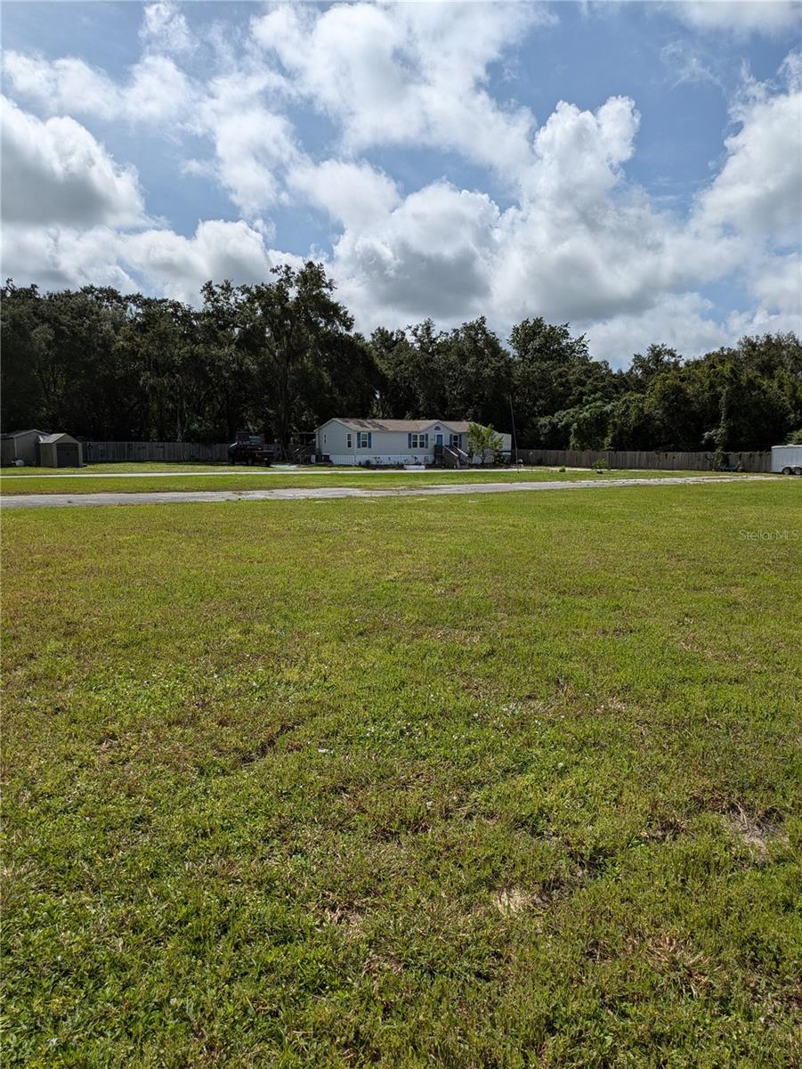 2.5 acre corner lot w/ 119 ft on US 41. This fully 6 ft wood privacy fenced parcel with a paved circular drive is fully cleared. A former mobile home park it now has a 4/2 1998 triple-wide manufactured home & another mobile home of mininmal value. Parcel access is off Pasco Acres Rd.