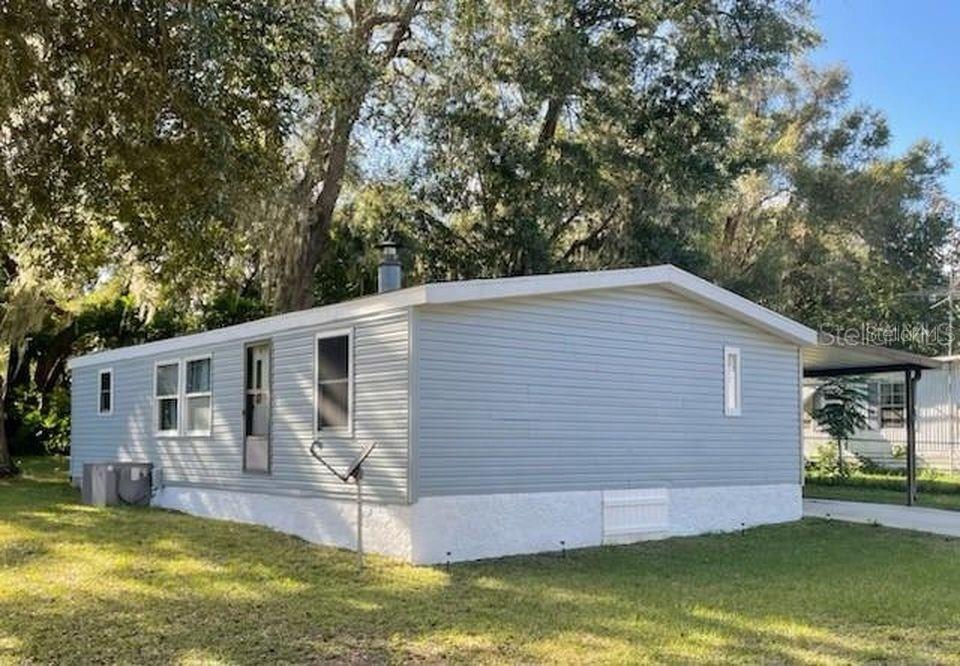 Own your own land. New HVAC. New Carpet. Newer Roof. 3 bedroom 2 bath . Large yard with extra storage building. Septic and well. Fireplace in Living room. Laundry in Utility room off the carport.. Located close to the Villages.