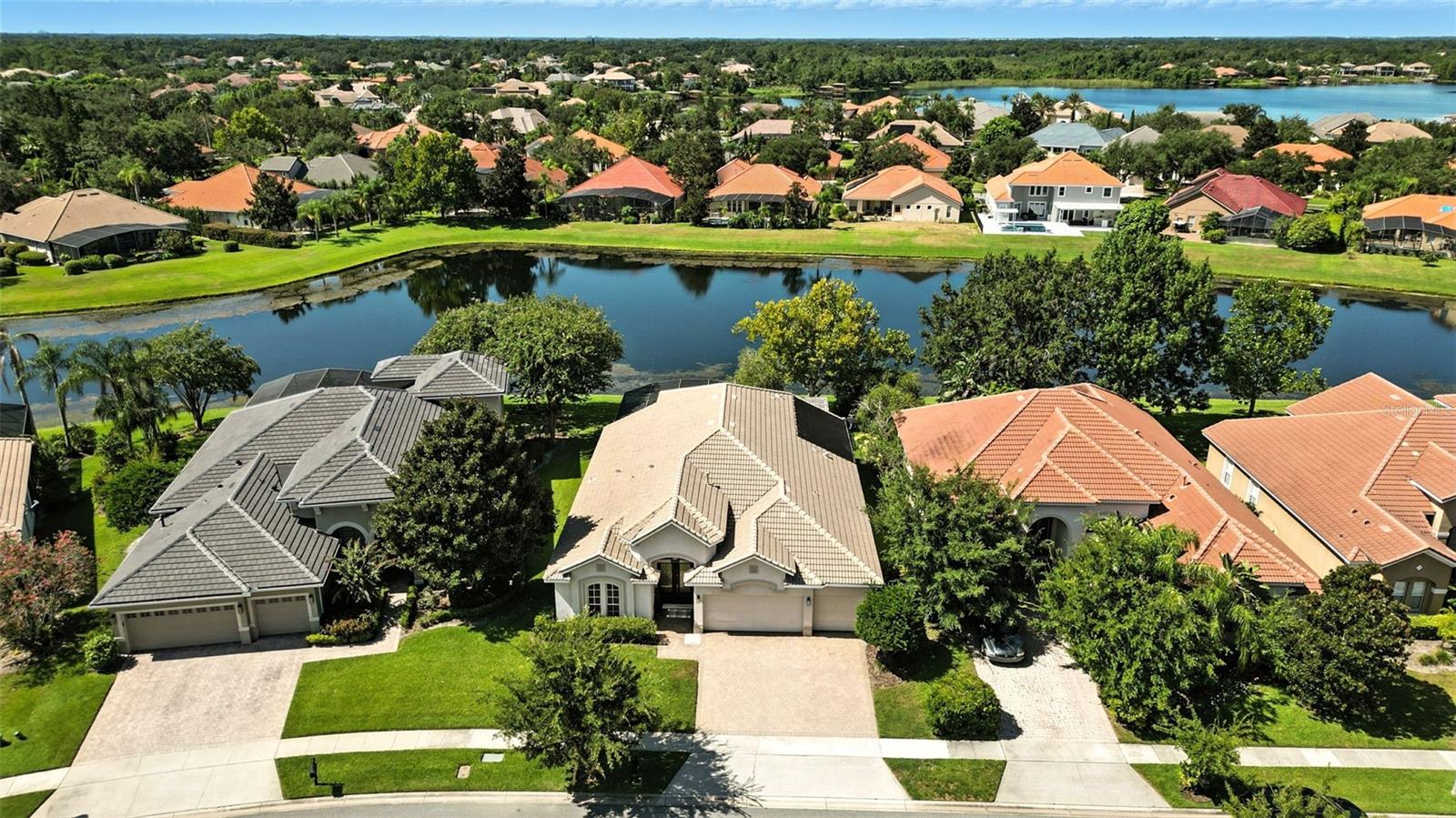 Stop the car, this is the home you will fall in love with! Unique opportunity to purchase a beautifully RENOVATED POOL home with WATER VIEW in the desired, GATED Belmere community. Exceptional home, meticulously cared for! This MOVE-IN ready home will check most of your boxes! Spacious layout all on one floor. Great SPLIT FLOORPLAN for privacy, NEW CUSTOM Kitchen, RENOVATED master bathroom, dark engineered hardwood flooring. The OVERSIZED master suite includes a seating area, custom built-ins and EN-SUITE bathroom with double sink and CUSTOM make-up vanity. The family room is spacious and a CUSTOM TV CABINET with integrated lighting makes this room cozy and functional! Do you enjoy the Florida lifestyle? You sure can in your own backyard with a sparkling, SOLAR HEATED POOL, WATER VIEW and an additional outside area with a GAS FIRE PIT with natural gas under a PERGOLA. 3-car garage with new epoxy flooring. This home would cost $1,000,000+ to build new! Describe this home in 3 words, it would be functionality, tranquility and serenity. You will enjoy PICTURESQUE SUNSETS from your own backyard! I will end my description here, call and schedule a showing quickly because this home will not last. Gated community with LOW HOA and great amenities. This residence is in a sought-after area with EXCELLENT SCHOOLS. Conveniently located near restaurants and entertainment, shopping and popular theme parks. **View this home 24-hours a day with our 3D interactive tour for your walkthrough experience!** We show only to preapproved buyers!