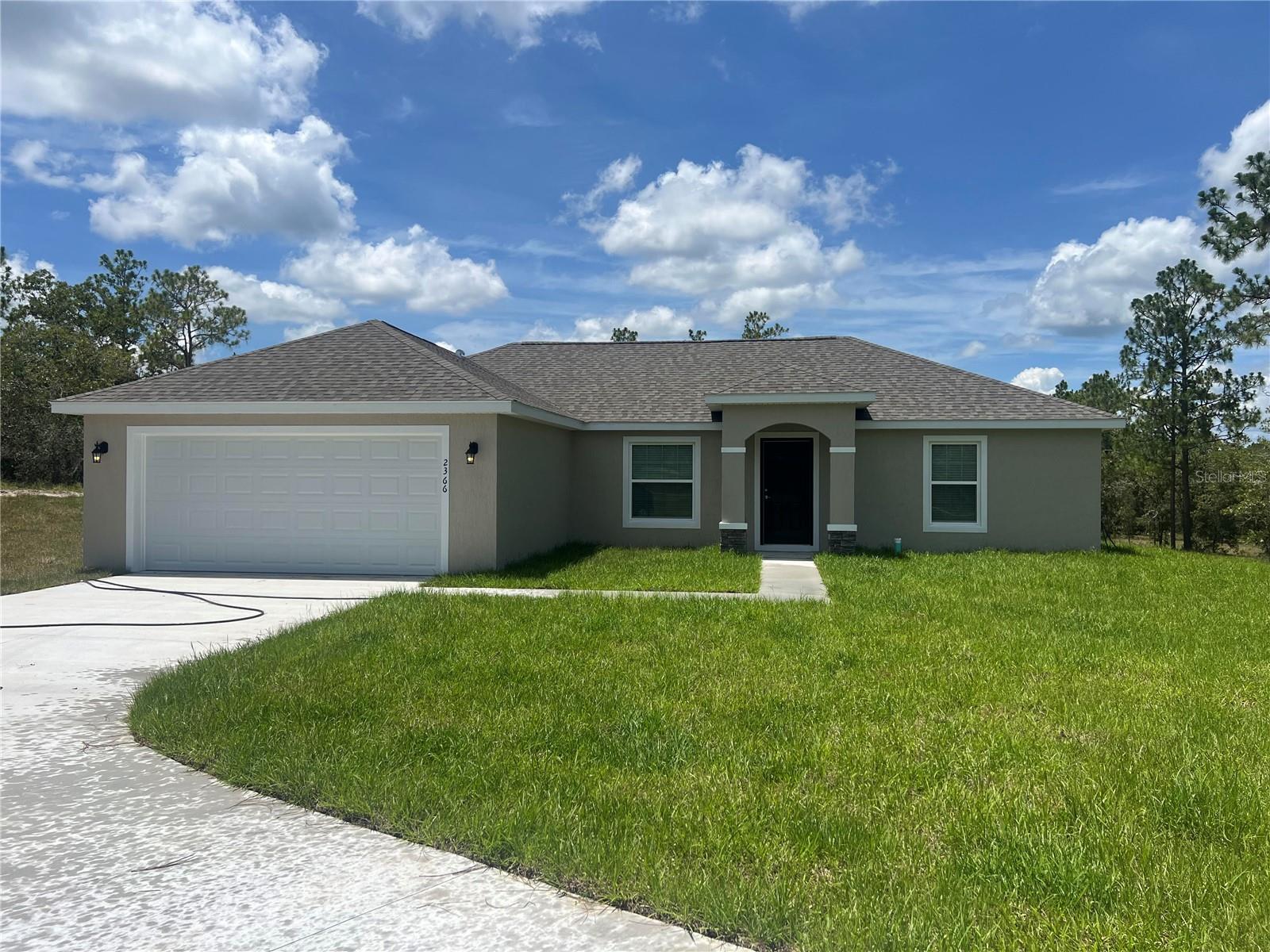 BRAND NEW! - EASILY OBSERVABLE! This Beautifully designed 3 Bedroom, 2 Bath, split bedroom HOME, is nestled on a .99 acre, semi-private homesite in Rainbow Lakes Estate. 2366 SW ADMIRAL LANDING DR DUNNELLON, boasts 1,880 Sq. Ft. of fabulous features and upgrades! There is a well, septic system, and plenty of room for a pool. This HOME offers an attractive hip roof, front entry, accent stone at the columns, two-car garage, block construction, hand troweled stucco finish, double pane insulated windows, and colonial style windows on the front elevation. As you enter this open and spacious, split bedroom home, you are welcomed into 1,407 sf. ft. of living space, vaulted ceilings, interior laundry room with washer and dryer hook-ups, linen closet and shelving. Enjoy this lovely kitchen with gorgeous granite, double under-undermounted stainless steel kitchen sink, pull-out faucet, white cabinetry, self-close doors and drawers, decorative hardware, and stainless-steel appliances (side by side refrigerator with ice-make and water in the door, microwave, dishwasher, glass stop range and disposal). Luxury Vinyl flows throughout the home. The primary suite offers a large walk-in closet and the primary bathroom showcases a double "adult height" vanity, granite countertops, undermounted sinks, and tiled shower. The other two spacious guest bedrooms, each offer a walk-in closet, light (pre-wire for fans) and share the guest bathroom. The guest bathroom features an adult-height vanity, granite countertops, undermounted sink and ceramic tiled tub/shower. This home is MOVE-IN READY! enjoy your evenings with family and friends grilling out on the rear patio. Let's make this HOME YOURS! CALL TODAY!