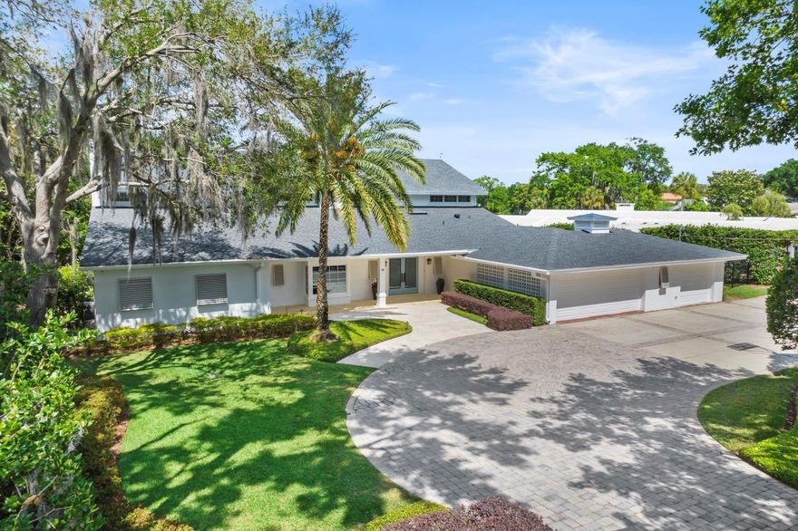 This elegant Winter Park lakefront residence offers luxury lakeside living, situated on the picturesque shores of Lake Osceola. This exquisite home invites you in with a grand circular driveway and meticulous, landscaped grounds, combined with elevated panoramic views from a spacious 3/4 acre lot, with approx. 140 feet on the street and approx.. 110 feet of prime lake frontage.  This property offers a sense of privacy, tranquility and breathtaking views capturing both northern sunrises & sunsets…
Inside, you'll find extensive renovations, over the years, that have elevated the space enhanced with Wolfe-Rizor Interior Design elements…  There is plenty of natural light throughout, with extensive windows, numerous French doors and a thoughtful layout that seamlessly blends indoor and outdoor living spaces. The primary level includes a defined foyer entry, secluded library/home office, kitchen, gathering room, formal living and dining rooms.  The chef’s kitchen is thoughtfully designed and enhanced by an expansive island, commercial grade range, lake side breakfast room, and catering area for creating culinary experiences in hosting family and friends.  The lavish living room includes room for a grand piano and has its own fireplace open to an expansive 30’ long dining room with direct lake views… along with a screened lanai...
The primary suite is conveniently located on the ground floor, offering a private expansive retreat with a sitting area and serene, picturesque lake views. The luxurious primary bathroom provides a spa-like experience including modern fixtures, his/her separate baths, and a generous walk-in closet/dressing room.  The main level also includes a potential 6th bedroom used previously for a caretaker’s quarters tucked away by the garage entry...
The upstairs living areas, include 4 additional bedroom suites (generous sizes) located on the second floor with a couple of bonus/flex rooms and sitting area... When you're not savoring the indoor elegance, step outside to enjoy the lakefront living with entertaining terrace, tropical pool, sprawling lawn with retaining walls, boathouse and majestic cypress, oak & palm trees to enhance the lakefront lifestyle...
Located on private, quiet street with oversized 3-car garage… Note: roof replaced in 2021.  All within walking distance to downtown Winter Park and famed Park Avenue…