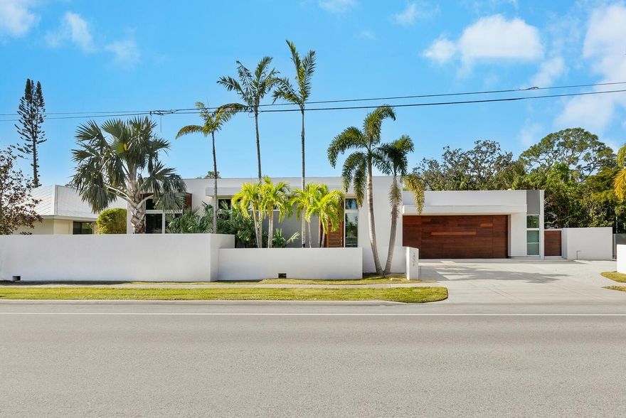 Experience the pinnacle of modern design and impeccable craftsmanship in this stunning architectural masterpiece West of the Trail. Perfectly situated in the heart of Southside Village, this extraordinary residence showcases a harmonious blend of streamlined concrete and warm mahogany, delivering a striking visual appeal that resonates with today’s discerning buyer. Designed with precision bronze-level Green construction standards, this home offers unmatched quality and eco-conscious living. Step into the warm and inviting interiors, where a floor-to-ceiling moving glass wall seamlessly connects the living space to the private backyard oasis. The result is an effortless fusion of indoor and outdoor living, creating an ideal setting for entertaining. Outside, you’ll find an extra-wide 40’ lap pool, a relaxing hot tub, a fire pit, and a grill, all surrounded by lush foliage and serene gardens that provide unparalleled privacy and tranquility. Inside, every detail has been thoughtfully curated. The open floor plan is awash with natural light, highlighting premium finishes such as quartz countertops, a large center island perfect for informal gatherings, and top-of-the-line appliances. The interiors, furnished by a highly talented European designer, exude elegance and sophistication, emphasizing the seamless flow between indoor and outdoor spaces.
This low-maintenance, eco-friendly home boasts cutting-edge features, including a tankless water heater, commercial-style linear air vents, level 5 premium drywall, Miami-Dade-rated PGT architectural series windows and doors, and an advanced smart home system. In addition to its exquisite aesthetics, the home offers incredible functionality with ample storage throughout and an oversized two-car garage, providing plenty of room for all your toys and gear. This property is being sold fully furnished, making it a rare opportunity to own a turn-key retreat designed for both comfort and entertaining. With its unrivaled location, exceptional design, and outstanding features, this home is more than a residence—it’s a lifestyle.