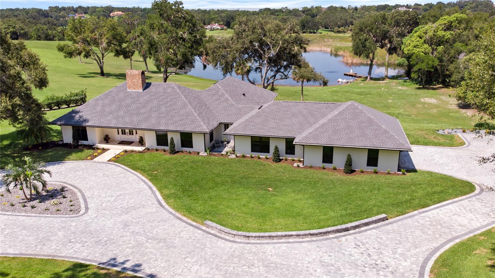 Welcome to this TURN KEY luxurious and spacious FULLY REMODELED lake front home. With views of Bok Tower and a large back yard overlooking Mountain Lake, this 3 bedroom, 3 bathroom, 2 half bath, residence with office space is located in the distinguished gated community of Mountain Lake. This home boasts high-end finishes and features throughout, including crown molding, custom cabinetry, NEW paver driveway, NEW landscape and irrigation, NEW roof, NEW windows, NEW tankless gas water heater, NEW hardwood floors, NEW AC units, NEW insulation, NEW dock boards with a clean lakefront, and aquatic weed control. The open-concept living area is perfect for entertaining, with a large open living room, wet bar with built in ice maker, formal dining area with seating up to 10 guest, and a gourmet kitchen with stainless steel Thermador appliances, a large island with seating, reverse osmosis filtration water system, and granite countertops. The master suite is a true retreat, overlooking Mountain Lake, with a spa-like bathroom featuring a jacuzzi tub, separate walk in shower, dual vanities and a large walk-in closet with built in cabinets. The two additional bedrooms are generously sized with their en suite bath and large closets. A laundry room with ample storage space and 1/2 bath leading to a two-car garage. The community offers exclusive amenities such as the Colony House with dining venues, Pool House, Trap and Skeet, Fitness Center, Tennis Courts, Seth Raynor golf course, and Croquet, thus providing it's residents with a luxurious and convenient lifestyle. As an added bonus Mountain Lake is also committed to preserving the natural beauty of the surrounding area, with a focus on conservation and sustainability. This home comes partially furnished unless determined otherwise by buyer.