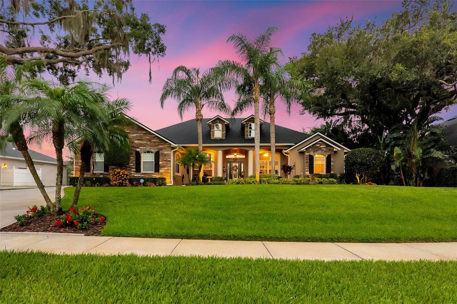 Under contract-accepting backup offers. This is an exceptionally unique property, and as good as it looks in photos, you need to see it in person to fully appreciate its elegance and charm. Immaculately maintained, custom-built, 1-story home on a large lot with lush landscaping, a park-like, fully fenced backyard, and an in-ground pool with screen enclosure. This residence showcases a well-thought-out split floor plan featuring exquisite wood and tile floors throughout. Less than 1 mile south of Lake Nona, the moment you arrive you will fall in love with its gorgeous southern live oaks draped in Spanish moss, a stacked stone façade and the traditional front porch contributing to the property's immense curb appeal. Entering the home, guests are greeted with a picturesque view of the gorgeous pool and backyard framed by the French Doors in the formal living room. The double tray ceiling and columned entry create an air of sophistication that permeates throughout. To the left of the foyer, a formal dining room awaits, ready to host memorable gatherings. On the right, a versatile fourth bedroom overlooks the front yard, currently serving as an ideal home office with built-in desk and cabinetry. Venture to your left, and a hallway leads you to the heart of this home—the gourmet kitchen. Prepare to be delighted by custom 42" cabinetry adorned with crown moulding and display cabinets, granite counters, a prep island, stainless steel appliances, and tile backsplash. The kitchen flows into the breakfast nook and generously sized family room, featuring wood floors, a tray ceiling, built-in surround sound speakers, and French doors that beckon you to the pool and patio area. In the opposite wing of the home, the owner's suite is a spectacular retreat with wood flooring, direct access to the rear patio, dual closets, and a spa-like ensuite bath with twin vanities and sinks, water closet, large soaking tub and separate shower. As you step outside onto the rear patio, you'll discover a backyard oasis beyond compare. The screen-enclosed, in-ground pool takes center stage, its tranquil water feature creating a soothing symphony for your morning coffee or evening cocktails. Surrounded by a sprawling brick paver pool deck, the pool area is a haven for relaxation and entertainment. The generous covered portion of the patio offers ample space to dine, lounge, and unwind, shielding you from direct sun and inclement weather. Impeccable landscaping embellished with planters, hedges, and bamboo, provides privacy and an exclusive ambiance to this oversized yard. Additional pavers outside the enclosure offer another serene seating area to enjoy the natural surroundings. Additional amenities elevating this home's allure include a laundry room adorned with custom cabinets and a granite folding counter, an oversized 2-car garage that ensures ample space for your vehicles and storage needs, and updates to nearly all major systems, including a new septic drain field (2022), HVAC system (2017), roof (2017), and water heater (2017), which provide peace of mind and a worry-free lifestyle. If you have fallen in love with the furnishings and decor, this home is optionally furnished with many of the pieces available for purchase. Zoned for top rated schools and ideally located 5 miles from Medical City, Lake Nona Town Center, Orlando VA Medical Center, Nemours Children's Hospital, and the UCF College of Medicine. Just a short drive from USTA headquarters and Orlando International Airport.
