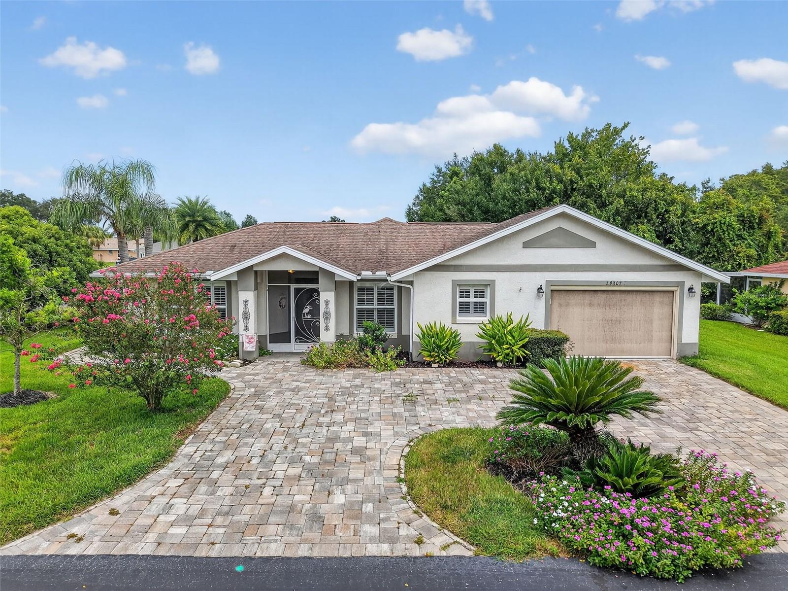 Located in the vibrant, guard-gated 55+ Tampa Bay Golf and Country Club, this beautifully updated extended Riviera floorplan sits on an oversized corner lot with serene conservation views from the back patio and golf course views from the lanai. With a paver circular driveway, tasteful exterior paint, and a welcoming screened front entry, this home offers curb appeal and comfort from the start.
Inside, the bright and open floorplan showcases modern white cabinetry, granite countertops, stainless steel pulls, a breakfast bar, and a custom pantry with pull-out shelves. The living and dining areas flow into a spacious enclosed Florida Room (13’ x 20’) with vinyl windows and an insulated roof—adding 260 sq. ft. of versatile entertaining space. The split-bedroom layout ensures privacy. The owner’s suite features a walk-in closet and a renovated ensuite bath with marble floors, dual sinks, and a beautifully tiled level entry shower. The guest bedroom, located on the opposite side, is paired with a flex space ideal for an office, den, sewing nook, or retreat. The upgraded guest bath offers a stylish vanity with granite countertops and a tub/shower combo. Your screened garage includes epoxy floors, utility sink, washer/dryer, storage, and a rear exit to the backyard oasis, where you’ll find a garden with herbs and plants like turmeric, lemongrass, aloe, peppermint, pineapple, oregano, and tomatoes—perfect for outdoor living and grilling.
Community Lifestyle:
Tampa Bay Golf and Country Club offers resort-style amenities including two pools (one resort-style heated with fountain, one adult-only), hot tub, 27 holes of golf, tennis, pickleball, bocce ball, shuffleboard, fitness center, dog parks, billiards, card rooms, library, clubhouse with a full-service restaurant and pub, banquet facilities, pro shop, activities center, and endless clubs, events, and entertainment.
With resident-owned amenities, a solvent HOA, and low fees that include cable TV, high-speed internet, and optional lawncare, you’ll enjoy a carefree lifestyle in this golf-cart-friendly community. Conveniently located with direct access to I-75, you’re never far from shopping, dining, and all this vibrant, welcoming community has to offer.