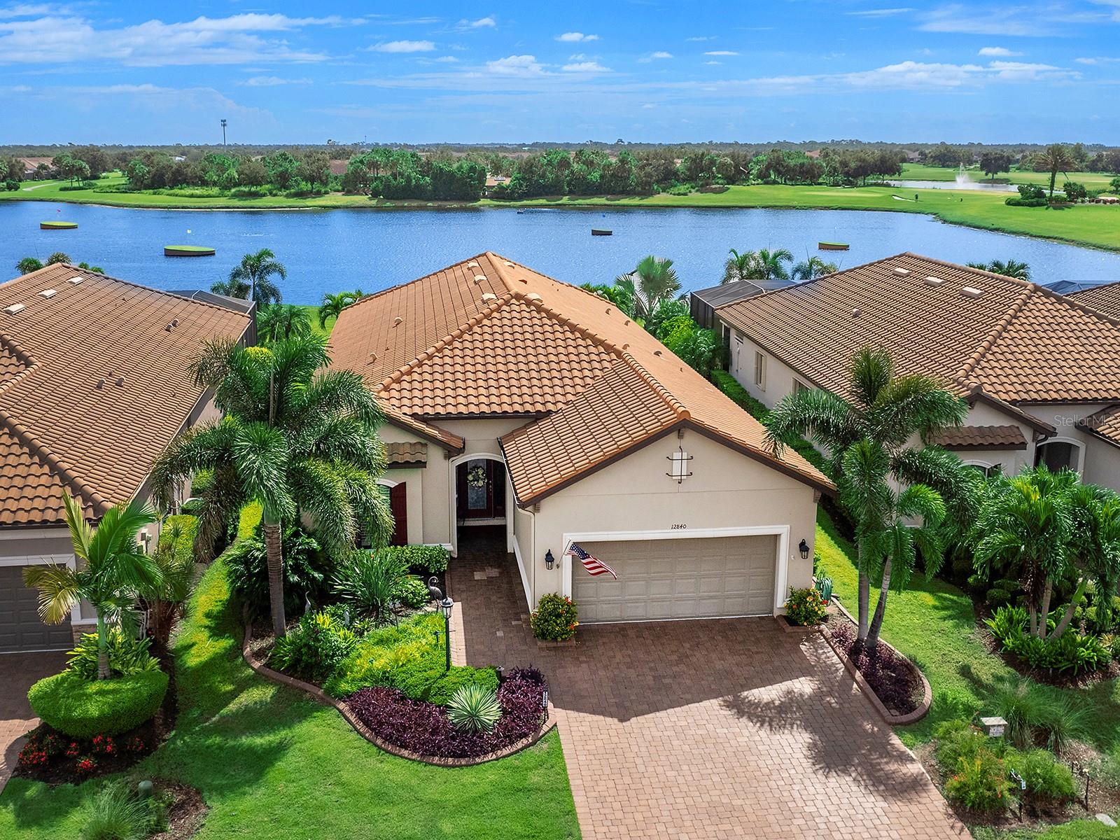 Tucked behind the gates of Esplanade Golf and Country Club in Lakewood Ranch, this golf-deeded residence showcases thoughtful upgrades and a well-planned design from the moment you arrive. The widened paver driveway, curbed landscaping, walkway lighting, and storm-resistant entry screens create a refined and practical exterior. Inside, the foyer introduces tile flooring that flows throughout the main living spaces, a tray ceiling with crown molding, and a custom front door with detailed windows. The kitchen was designed with functionality in mind, featuring a an oversized island with plentiful storage, upgraded soft-close cabinetry (some with pullouts), granite countertops, grey subway tile backsplash, stainless-steel GE Monogram appliances, and a wine refrigerator. A louvered pantry door and lighting over the island add to the details. The kitchen opens to a spacious dining area and the great room, which is finished with a tray ceiling, crown molding, recessed lighting, and ceiling-mounted surround sound. The primary suite features a tray ceiling with crown molding and a sitting area with plantation-shuttered bay windows. A large custom walk-in closet provides ample storage, while the en-suite bath offers an expansive granite-topped vanity with two sinks, an oversized seamless-glass shower with designer tiled and a window, porcelain tile floors, and a private water closet. A pocket door located near the foyer leads to a private guest wing, where the guest bedroom features a built-in wall closet, plantation shutters, and an adjacent full bath with a granite vanity and a linen closet. The dedicated office is equipped with built-in cabinetry, crown molding, recessed lighting, and a customized closet. A second guest suite includes a walk-in closet, plantation-shuttered windows, and a full en-suite bath with a vanity and tub/shower. The lanai extends living outdoors with beautiful pavers, storm-resistant remote-controlled shades, and a full outdoor kitchen, complete with an Alfresco grill and hood, sink, refrigerator, leather-finish granite counters, and built-in trash. Custom lighting, ceiling speakers, and views across the aqua driving range complement the saltwater pool with a Pentair control system. Additional conveniences include upgraded tile and paint throughout, installed lighting and ceiling fans in every room (including the primary closet and garage), storm screens for protection, and systems such as a whole-house water filter (2025), tankless water heater, surge suppression, and an A/C with mold-prevention infrared lights and specialized drainage filters. Esplanade Golf and Country Club at Lakewood Ranch is a gated community that offers a range of amenities including a state-of-the-art fitness center, a full-service spa, bocce ball, pickleball courts, a tennis club, fitness classes, walking trails, a dog park, a culinary center, a clubhouse, a heated lagoon-style pool with private cabanas, a resistance pool, and a full-service tiki bar and restaurant. This location is surrounded by top-rated schools and a short distance from dining, entertainment and shopping, including the popular UTC Mall, Lakewood Ranch Main Street, Waterside Place and more. This is a golf-deeded home.