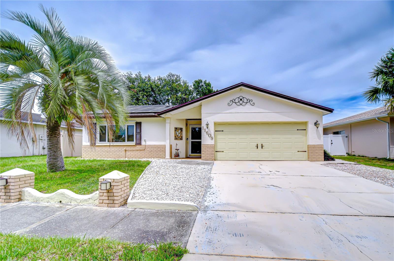 Welcome to 11609 Painted Hills Lane - in the heart of Central Carrollwood - the ultimate Florida lifestyle home! You can enjoy year round relaxation in the enclosed Florida Room with mini split AC/heat unit (2023), wood-burning fireplace and floor to ceiling windows. The dry bar and double french doors leading into the main house creates a space that will meet all of your entertainment needs or a comfortable night relaxing at home. This beautiful room overlooks your sparkling saltwater free form pool with an AquaCal TropiCal pool heater (2022). A rear patio adds to this resort lifestyle with the included table, chairs and a large umbrella. Your kitchen features custom made wood cabinets with seeded glass doors on the upper cabinets and pull out drawers below. Updated stainless steel appliances (dishwasher 2025 and stove 2023) are accented with a stunning tile archway over the range. A window over the double stainless steel sink overlooks the Florida room with a slider that opens up to the dry bar. A NEW ROOF installed 2025 boasts owned solar panels (2023) which slash electric bills to under $50/month. Ceiling fans throughout, and crown molding add to the tropical feel. Primary bedroom features coffered ceilings and ceiling fans an en-suite bathroom and a walk in closet. Built in surround sound stereo system throughout the home and outside complements the resort feeling. You are minutes to Citrus Park Mall, Carrollwood Village Park, Carrollwood Cultural Arts Center shops and many restaurants. Easy access to the Veterans Expressway, Dale Mabry, Tampa International Airport, beaches, sports venues and downtown Tampa! No HOA no CDD!!!! A must see to appreciate!