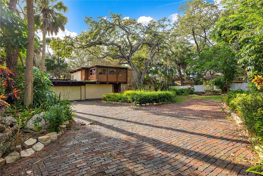 WATERFRONT 1.21 ACRE - JUNGLE TERRACE/HISTORIC PARK ST.  THIS MID CENTURY MODERN INSPIRED HOME IS A ONE OF KIND SANFORD GOLDMAN BUILD AND IS TRULY UNIQUE. SITUATED ON 1.2 ACRES OF GORGEOUS INTRACOASTAL WATERFRONT IN A TROPICAL SETTING LOCATED IN THE  PARK STREET AREA IS HARD TO FIND. 3 BEDROOMS, 2 BATHS, BONUS ROOM PLUS OFFICE.   OVERSIZED 2 CAR GARAGE 600 SQ FEET + STORAGE  & POOL.  UNIQUE ATRIUM ENTRY, OPEN FLOOR PLAN, BREATH TAKING WATER VIEWS AND SUNSETS.   3300 SQ FT OF LIVING SPACE.  MANY POSSIBILITIES.  FLOOR TO CEILING WINDOWS, CEDAR ACCENTS THROUGHOUT.  OPEN FLOOR PLAN, OPEN FIREPLACE SERVICES THE LIVING AND DINING AREA, LARGE KITCHEN WITH BUILT-INS. 1ST FLOOR BEDROOMS 1 AND 2 WITH BATH.  2ND LEVEL MASTER BEDROOM WITH LARGE SITTING AREA OVER LOOKING THE WATERWAY + OFFICE.   GORGEOUS LOT MEASURES 95X357.
SUBMERGED LAND  94FT OUT FROM PROPERTY INTO THE WATER. Room Feature: Linen Closet In Bath (Primary Bedroom).