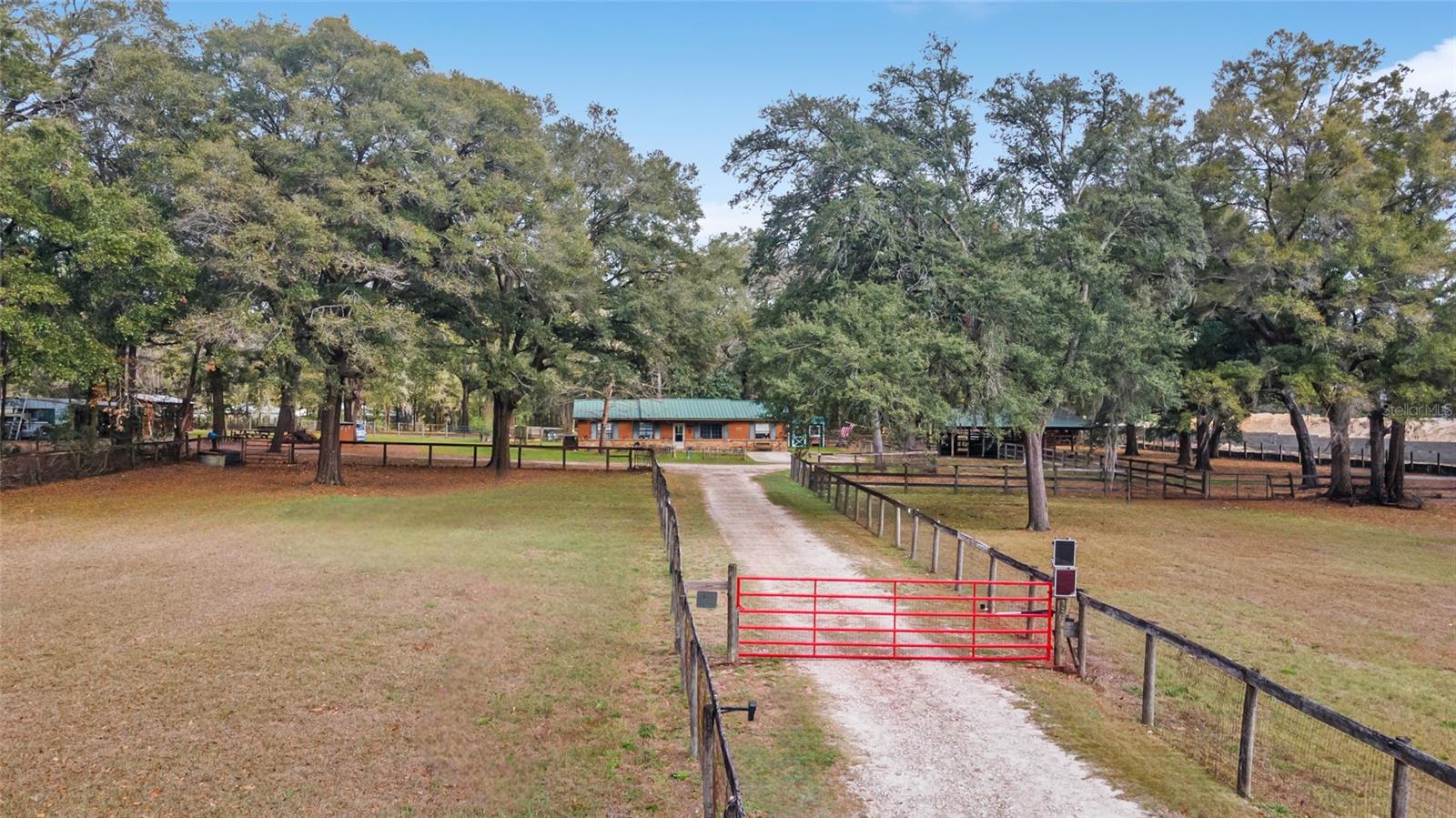 Charming Horse Farm Just Minutes from the City – A Rare Find in Ocala!
Nestled on nearly 5 serene acres with no-climb fencing and towering live oaks and magnolias, this equestrian property offers the perfect blend of rural charm and modern convenience. Located on a quiet cul-de-sac, yet just minutes from the renowned World Equestrian Center and Ocala’s best shopping, dining, and healthcare, this is a dream come true for horse lovers and nature enthusiasts alike.
The 3-bedroom, 2-bath home is designed for comfort, featuring large windows that bathe each room in natural light while offering picturesque views of the property. Wood-look tile flooring, ample storage, and a thoughtfully designed spacious living area create a welcoming atmosphere. The dining area and galley kitchen flow effortlessly into a large laundry room with abundant cabinetry, perfect for extra storage or a huge pantry.
Step outside to the expansive screened porch and adjoining patio—an idyllic spot to enjoy your morning coffee, unwind with a glass of wine, or entertain guests while overlooking the paddocks.
Equestrians will appreciate the 6 horse paddocks and the center-aisle pole barn, ready for you to customize with your own stalls. Additional outbuildings include a sizeable shed (ideal as a workshop or potting shed), a detached 3-bay garage with electric and water, and a storage shed with an attached chicken coop and run.
Recent updates include whole-house plumbing, A/C, hot-water heater, and laminate flooring in bedrooms and kitchen.
Whether you’re an avid rider, hobby farmer, or someone who simply craves peaceful country living without sacrificing city amenities, this property is a rare gem in the heart of Florida’s Horse Country.
?? Minutes from World Equestrian Center & Ocala’s Best Amenities
?? Move-In Ready 3BR/2BA Home with Scenic Views
?? 6 Paddocks + Customizable Pole Barn
?? Towering Oaks & Tranquil Setting
?? Detached 3-Bay Garage + Multiple Outbuildings
This one-of-a-kind property won’t last long—schedule your private tour today