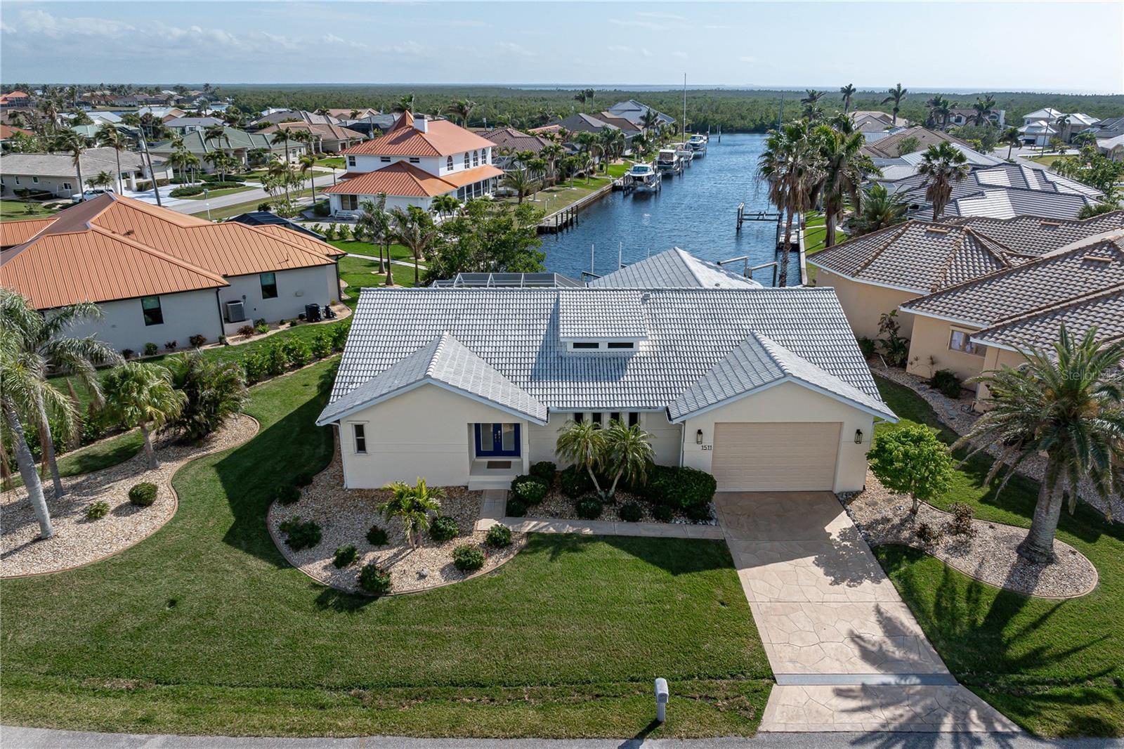 UPDATED WATERFRONT POOL HOME W/RARE AIR-CONDITIONED 4-CAR GARAGE, LONG CANAL VIEW, SOUTHERN EXPOSURE & QUICK SAIL ACCESS VIA BUCKLEY’S PASS – This meticulously upgraded 3 bed/2 bath home in Punta Gorda Isles checks all the boxes for serious boaters and those seeking the ultimate Florida lifestyle. Located on a premium southern-exposure lot, the home offers a panoramic view straight down a wide canal culminating at the perimeter waterway—perfect for catching the lighted holiday boat parade each year as it floats by. Depending on your destination, you can reach open water two ways from your private dock w/10,000 lb boat lift — either through Buckley’s Pass or the scenic route along the perimeter canal via Ponce Inlet. The oversized, tandem-style 4-car garage is a true standout, featuring 10-ft ceilings, a dedicated mini-split A/C, epoxy flooring & ample space for vehicles, gear, hobbies or weekend projects. Step inside to a light-filled, contemporary interior with soaring ceilings & updated finishes throughout. The layout is open & effortless, with a seamless flow between the great room, formal dining area, & family room—perfect for entertaining or just enjoying the spaciousness. A wall of glass sliders opens wide to the lanai, blurring the line between indoors & out. At the heart of the home, the updated kitchen will impress. It’s outfitted with custom wood cabinetry, sleek quartz counters, a dual-fuel oven with gas cooktop, glass tile backsplash, walk-in pantry, & a generous breakfast bar that doubles as the perfect gathering spot. The master suite feels like a retreat, complete with cathedral ceilings, its own sitting area with lanai access, an oversized walk-in closet designed for optimal storage, & a spa-inspired bath featuring dual sinks set in a natural cherry vanity, quartz countertops, a luxurious walk-in shower with both rain and handheld shower heads, & a private water closet. The split-bedroom layout ensures privacy, with two spacious guest rooms offering water views—one with direct access to the lanai. The guest bath has been stylishly renovated & also functions as a pool bath. Laundry doesn’t get overlooked either: the updated utility room includes shaker-style cabinetry, dual storage closets & room for high-efficiency washer/dryer. Outside, the screened lanai wraps around the in-ground pool, which was resurfaced in 2024 with new waterline tile & a refinished deck. It’s the perfect space to unwind or entertain, all while soaking in that long water view. Keep your boat docked in the backyard. Water & electric hook-ups are available dockside. Additional upgrades include fresh interior and exterior paint, replumbed overhead piping, app-controlled irrigation, LED lighting, Levelor remote-controlled blinds, & a Ring security system. The home also offers whole-house hurricane protection w/additional storm barrier at garage. Mature tropical landscaping surrounds the home w/new sod installed in 2023. Great location on a quiet street yet still close to everything. Miles of sidewalks in PGI connect you to numerous parks, St Andrews South golf course, Fishermen's Village, the Isles Yacht Club & historic downtown. Whether walking, biking, or driving, you’ll find yourself close to shopping, dining, & entertainment. If you’re looking for that rare combination of serious boating access, upgraded interior spaces, & a garage that can hold it all—this home delivers. Make an appointment to see it today.