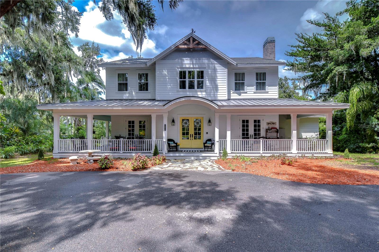 MULTI-HOME Lutz Lakefront Estate: Old Florida charm, natural beauty, serenity and breath-taking sunsets meet the modern farmhouse style and design of this custom home. Your entrance on the tree-lined driveway leads to a “hidden treasure” meticulously placed on 3.91 acres of lakefront paradise. ASC-1 zoning allows for horses plus 128’ of private frontage on 30-acre ski-size Lake Keen, yet property is just minutes from the best of Tampa. With a combined living space of 6944 sqft, this unique property includes Main lakefront house, PLUS separate Guest House, separate Auxiliary dwelling (perfect for home business), oversized 2-car detached garage with full bath plus second floor living area. One of many beautiful details in the main house, the large foyer, is welcoming with double-door entrance leading to the grand staircase with lighthouse-style newel post. This easy-living home boasts wide plank wood flooring, chef’s kitchen with farmhouse sink, butler’s pantry, walk-in pantry, over-sized island with seating for six, breakfast area banquette (think gatherings in the kitchen) convenient and spacious laundry/mudroom with tons of storage, built-in extra refrigerator and adjacent office; large dining room with custom wainscoting and double door access to the front porch; Great Room with gas fireplace; Study/Den/Library with decorative gas fireplace, custom book shelving and cozy reading nook, double door access to the wrap around front porch; primary bedroom with picturesque lake views, luxurious primary bath boasting a Hydrologic soaking tub and walk-in shower with multiple shower heads, custom designed walk-in closet, double door access to screened back porch with gas fireplace where you can enjoy your morning coffee and evening sunsets overlooking serene Lake Keen. Even a Sunbrite Outdoor TV for Game Day! Upstairs, the gallery leads to custom bunk room with two walk-in closets; two additional bedrooms connect through Jack and Jill bath with barn door entries; fourth bedroom with adjoining hall full bath and a bonus room. The feature list of this energy-efficient home includes extensive custom KraftMaid Shaker-style cabinetry, Caesarstone Quartz countertops, Monogram professional stainless steel kitchen appliances, Heat & Glo remote-controlled gas fireplaces, beautiful custom ceramic and stone tile work, including subway and mosaic designs. Power goes out? No problem with a Kohler 20Kw whole house generator. Control 4 Home Automation and Networking system is operated via a smartphone app. Fingertip control of Alarm system, Thermostats, Security Cameras, lighting, Audio/Video, internet/WiFi. All electronic components in this system will convey, including 7 flat-screen, mounted TVs, in-wall subwoofer for the Great Room surround sound system and in-ceiling speakers throughout. To complete your outdoor needs, multiple porches offer views of morning sunrises and spectacular vistas of expansive property. Also included are two large“Tuff” sheds and a pump house for well equipment. Custom built treehouse playground for the kids, trees and plants galore, a horticulturalist’s dream. Guest house, fully renovated in 2017, offers a full kitchen, full bath, laminate flooring, network services, mounted flat-screen TV, Nest Thermostat, and large screened porch. This property has it all, plus easy access to top-rated educational institutions and medical facilities. Don’t miss out on this captivating property. Schedule your tour today!