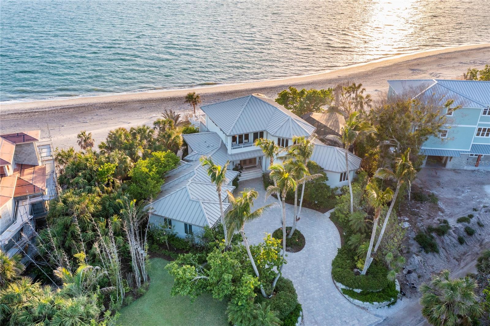 Welcome to your own private coastal retreat—where your backyard is the beach and every day feels like a getaway. This rare, direct beachfront estate on North Manasota Key delivers the ultimate in tranquility, seclusion, and barefoot luxury on one of Florida’s most coveted barrier islands.
Tucked within an exclusive, gated community of fewer than 80 homes along a serene two-mile private road, this property offers a lifestyle defined by natural beauty and relaxed elegance. With approximately 135 feet of pristine Gulf frontage and 147 feet on the Bay, all set on more than an acre of land, this elevated haven (rising 15 feet) captures the essence of true coastal living. NO DAMAGE OR WATER INTRUSION IN THE HOUSE FROM HURRICANE HELENE OR MILTON!
Step inside to 4,533 square feet of sun-drenched interiors where panoramic water views steal the show. An open-concept layout connects the main living spaces, perfectly designed for hosting and relaxing—whether you’re gathering around the dining table or savoring morning coffee with nothing but sea and sky in view.
The chef’s kitchen features generous cabinetry, new Dolomite countertops, ample storage, and windows that frame both the Gulf and the pool, blending indoor comfort with natural inspiration. Just outside, the shell-stone lanai is your private oasis: a heated pool and spa surrounded by lush native gardens, a built-in Wolf grill, skylights for natural light, and a pool bath for added convenience—all just steps from the sand.
The home’s thoughtful layout provides separation and privacy for family and guests. Two ensuite bedrooms on the ground floor are positioned in their own wings, while a flexible third ensuite—currently used as a den—can easily become a fourth bedroom, also having a large storage closet and beautiful Gulf views. Upstairs, the spacious master suite is a peaceful retreat with stunning beach and bay views, with a two-sided fireplace, sitting area, spa-like bath, and a private Brazilian walnut wood deck overlooking the Gulf. A second covered balcony on the bay side and a refined office with custom built-ins round out the upper level.
Meandering stone paths wind through lush, newly landscaped grounds adorned with vibrant orchids and native palms, guiding you to a brand new beach walk-out and your own secluded stretch of sand. A thoughtfully engineered sand berm provides vital protection against beach erosion, offering peace of mind and preserving your pristine shoreline for years to come. Along the way, discover multiple shaded and open-air sitting areas—perfect for morning coffee, sunset views, or simply soaking in the serenity of this coastal haven. Here, you can stroll the shoreline in search of seashells and shark’s teeth, watch dolphins play at sunset, or simply unwind with your toes in the sand. On the bay side, your recently resurfaced private dock (2024) and upgraded 10,000 lb boat lift (2023) offer endless opportunities for boating, fishing, or paddleboarding.
Though it feels a world away, you're just minutes from golf, tennis, dining, boutique shopping, and top-rated schools.
This is more than a home—it’s a beachfront sanctuary, where life slows down and every day feels like a vacation.