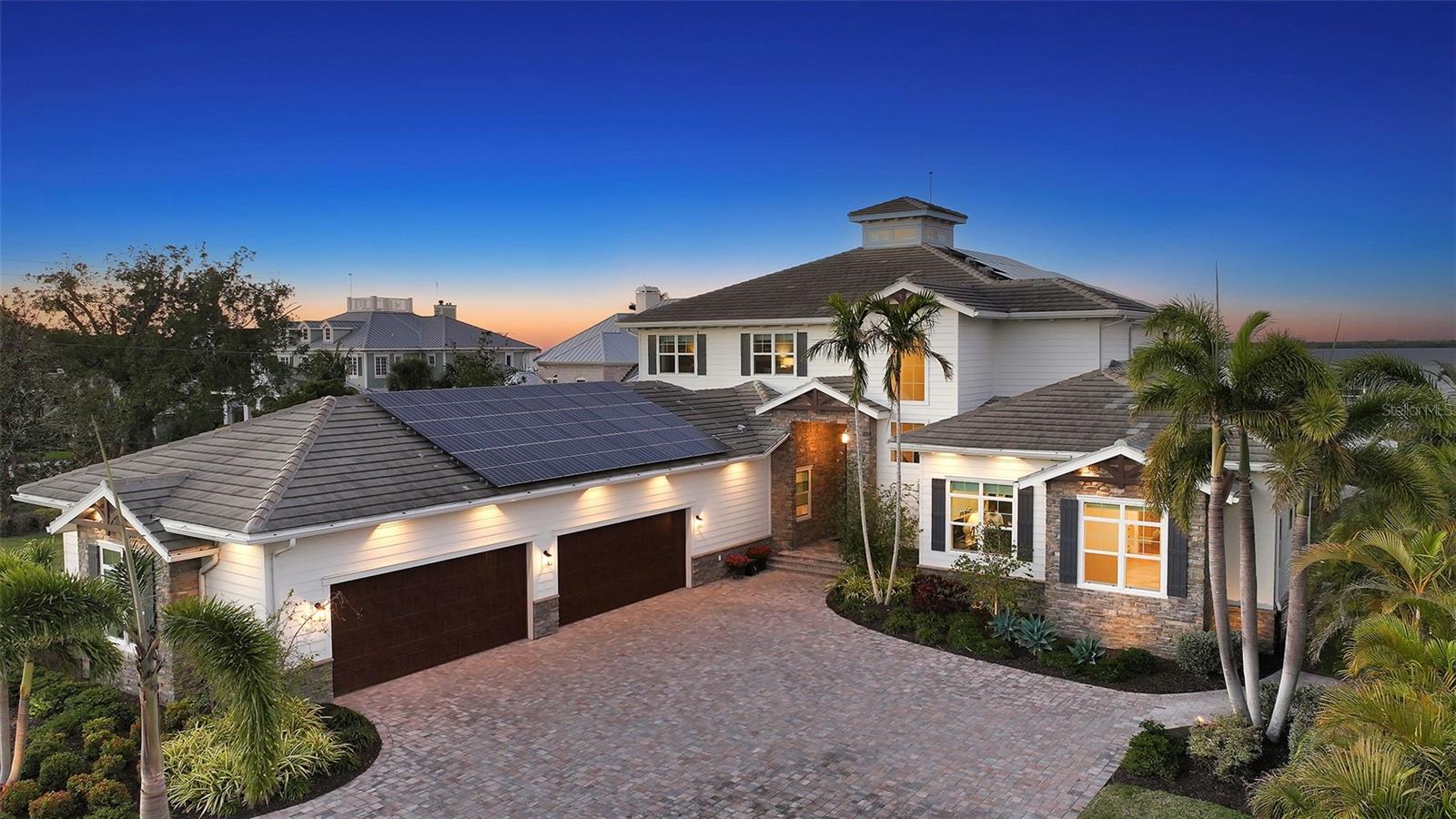 Embodying the pinnacle of storm-resilient luxury, this exceptional waterfront estate is thoughtfully fortified with premier safety features. Solar panels paired with backup batteries seamlessly operate the first floor of the main home and fully power the guest house during outages. A 500-gallon buried propane tank, concrete roof tiles, hurricane impact glass throughout, and a full suite of electronic and metal hurricane shutters — including five remote-controlled systems enclosing the main floor covered lanai and second-floor remote screens — offer peace of mind through every season.
A true boater’s paradise on the Manatee River, this modern custom estate offers direct access to the Gulf of Mexico, with idyllic destinations like Anna Maria Island, Longboat Key, Sarasota, and St. Petersburg just moments away by water. Built in 2020 and spanning 6,621 square feet, the residence combines architectural elegance with cutting-edge smart home technology for effortless living. Situated on elevated, flood-free ground, the home has weathered all storms unscathed, according to the owner.
The main residence and 1,344-square-foot guest home together feature a seven-car garage, ideal for collectors or additional storage. Inside, five bedrooms, five full and two half baths are thoughtfully designed with premium finishes, including engineered hardwood flooring and hurricane-rated materials. The primary suite is a serene retreat, boasting a luxurious steam shower with 13 spray heads, soaking tub, towel warmers, and travertine tile. A gourmet kitchen is equipped with Wolf, Sub-Zero, and Bosch appliances, dual islands, and an expansive walk-in pantry with a built-in Sub-Zero freezer.
Designed for grand entertaining, the living room features coffered ceilings, a gas fireplace, and custom cabinetry, while the expansive lanai redefines outdoor living. Nearly 3,800 square feet of screened space includes a bespoke outdoor kitchen, two-sided fireplace, saltwater pool with spa and sun shelf, and a poolside half bath—all secured by remote hurricane shutters. The guest home offers two bedrooms, a luxurious kitchen, impact glass, and a private balcony.
Additional features include an electronic gated entry, lightning and surge protection, cement roof shingles, and a solar-powered system with four backup batteries. Boating enthusiasts will appreciate the five-foot TREX dock with a 16,000-pound boat lift, a 4,500-pound personal craft lift, and a powered utility shed. A private weather station provides real-time monitoring. Located within walking distance of De Soto National Memorial Park, this one-of-a-kind estate offers an unmatched lifestyle of safety, sophistication, and waterfront serenity.