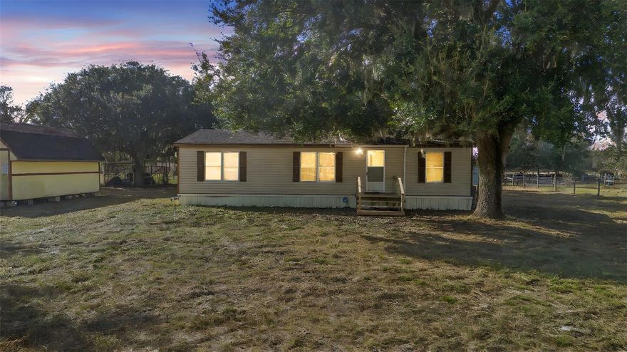 Set on six fully fenced acres, this property offers the space and freedom many buyers are seeking. A gated entrance welcomes you to a peaceful setting well suited for animals and outdoor living. The double-wide mobile home features three bedrooms and two bathrooms with a practical, comfortable layout. The land is thoughtfully prepared for agricultural use, with room for cattle, horses, chickens, or other livestock. Stables, tacks room and a large shed provide valuable storage and functional workspace, making day-to-day operations easy to manage. Whether you’re looking for a quiet rural retreat or a property that supports a working lifestyle, this home presents a rare opportunity to enjoy acreage, privacy, and versatility. Schedule your showing to experience the potential firsthand.