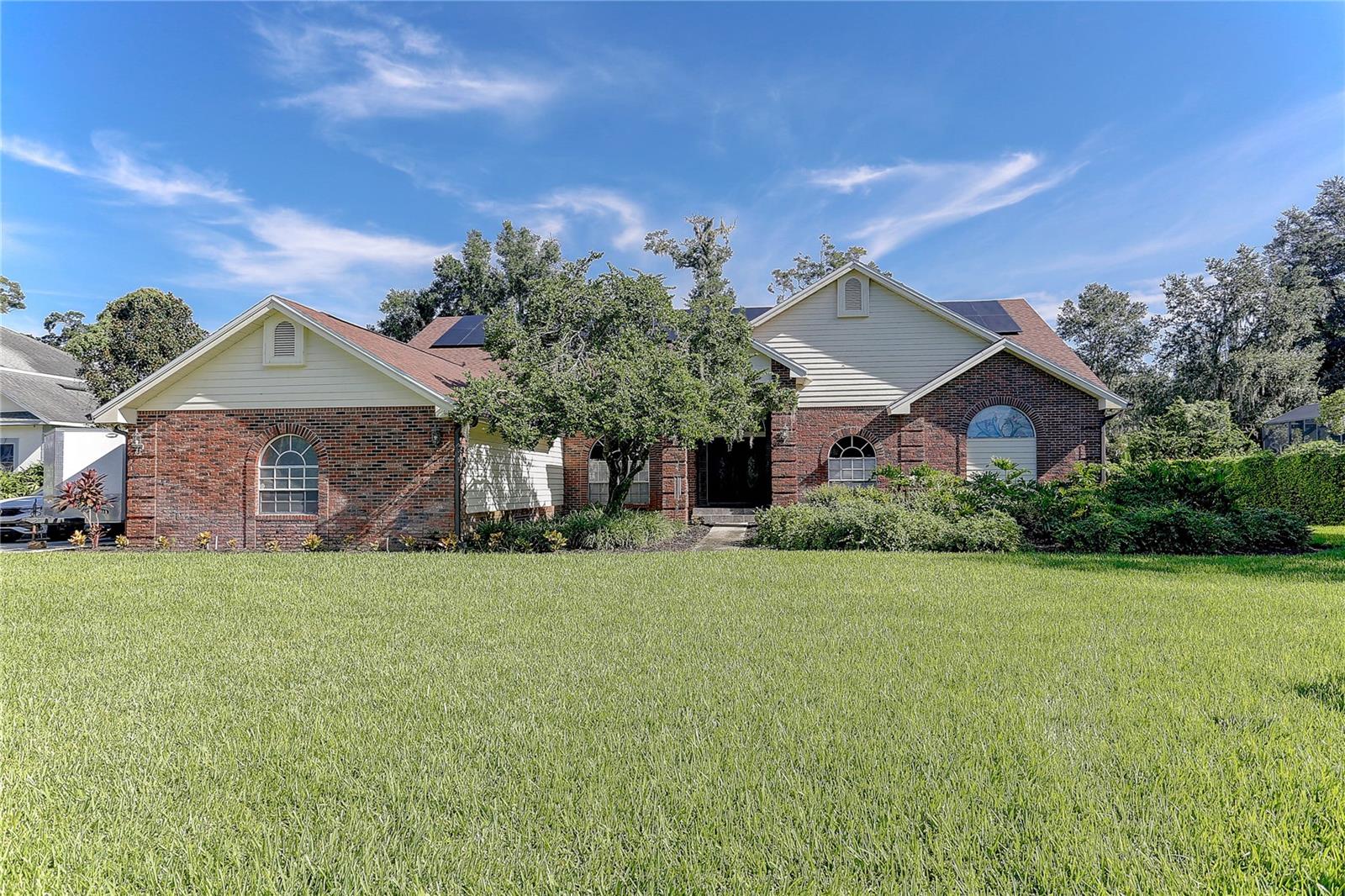 Outstanding remodeled 5 bedroom, 3 bath, 3 car garage pool home located in one of Valrico’s most sought-after communities, Country Gate. This 3,281 sq. ft. heated and cooled single-story ranch, with a total of 4,673 sq. ft. including the garage and lanai, is set on a beautifully landscaped .54 acre cul-de-sac lot. The all-concrete block exterior is accented with real brick and complemented by a brand-new 2025 roof, while solar panels provide energy efficiency and reduced power bills. The backyard features a sparkling open salt water pool with a heated spillover spa, and the expansive 506 sq. ft. lanai offers vaulted ceilings, two new skylights and a wet bar with countertop and cabinetry. Oversized 8’ sliding glass doors connect the lanai and pool area with the primary suite, the formal living room and the family room. In addition to the side-entry 3 car garage, a 10’ x 20’ shed provides extra storage for lawn equipment. Over the last four years, the home has undergone extensive renovations including a new kitchen, three new bathrooms, two new A/C systems, laminate flooring throughout all living areas, fresh interior paint, two new garage doors, a new pool pump and equipment, and a new water heater. Inside, soaring vaulted ceilings enhance the spacious design. The primary suite features a walk-in closet and a fully remodeled bath with new cabinetry, tile, a soaking tub, walk-in shower, double vanities with solid-surface countertops, and a private water closet room with a bidet. The 2nd bedroom, complete with a closet, double French doors, crown molding, and custom trim, shares access to the primary bath and functions perfectly as a bedroom, office, or nursery. The true three-way split floor plan offers privacy with the primary suite and office/ 2nd bedroom on one side, bedrooms 3 & 4 plus bath #2 on the guest side, and off the back of the home bedroom #5 and bath #3 that also serves as a pool bath. The kitchen showcases new cabinetry, granite countertops, marble backsplash, stainless steel appliances, a coffee/dry bar, and a separate wet bar with sink and beverage fridge that opens to the family room with bar seating. The formal living and dining rooms also feature vaulted ceilings and a clerestory window overlooking the lanai, with the dining room highlighted by an exquisite chandelier. The raised entry welcomes guests with beautiful solid wood double doors leading into the elegant yet open formal spaces. The family room is anchored by a large brick fireplace with a raised hearth, and the seller is including the wall-mounted TV. Every detail of this home has been thoughtfully remodeled with quality materials and professional craftsmanship, creating a truly impressive property. Please take a moment to view the professional photos and virtual tour, then contact your Realtor to schedule a private showing.