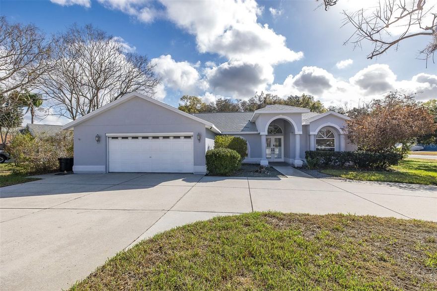 One or more photo(s) has been virtually staged. Welcome to Ellington Estates, where comfort, flexibility, and thoughtful updates come together in this spacious pool home situated on an oversized corner lot. Offering four bedrooms, 2½ baths, plus a dedicated office, this split floor plan provides both privacy and versatility to fit a variety of lifestyles. Thoughtfully modified for ADA accessibility, the home features widened doorways throughout much of the property and updated bathroom accommodations for ease and comfort. The heart of the home is the fully remodeled kitchen (2020), which opens seamlessly to the living area and overlooks the solar-heated saltwater pool—perfect for everyday living and entertaining. The generous primary suite features direct pool access, a large walk-in closet, and an ADA-compliant en-suite bath with widened doorways and a roll-in shower. The secondary bedrooms are well-sized, each with large walk-in closets, and share a full bath that conveniently doubles as a pool bath. A third bedroom includes its own half bath with direct access to the garage, offering ideal functionality for guests or multi-generational living. Two additional flexible rooms provide endless possibilities—use them as a fourth bedroom, office, hobby space, or fitness room. The oversized laundry room includes abundant storage and a utility sink. Step outside to enjoy the private, fenced backyard, spacious lanai, and resurfaced pool (2018), creating a true Florida outdoor retreat. Major updates offer peace of mind, including a new roof and A/C (2020), water heater (2022), and fresh exterior paint (2026). Ideally located near top-rated schools, shopping, dining, golf, parks, and medical facilities, this home delivers the space, updates, and location that make Trinity one of the most desirable places to live.