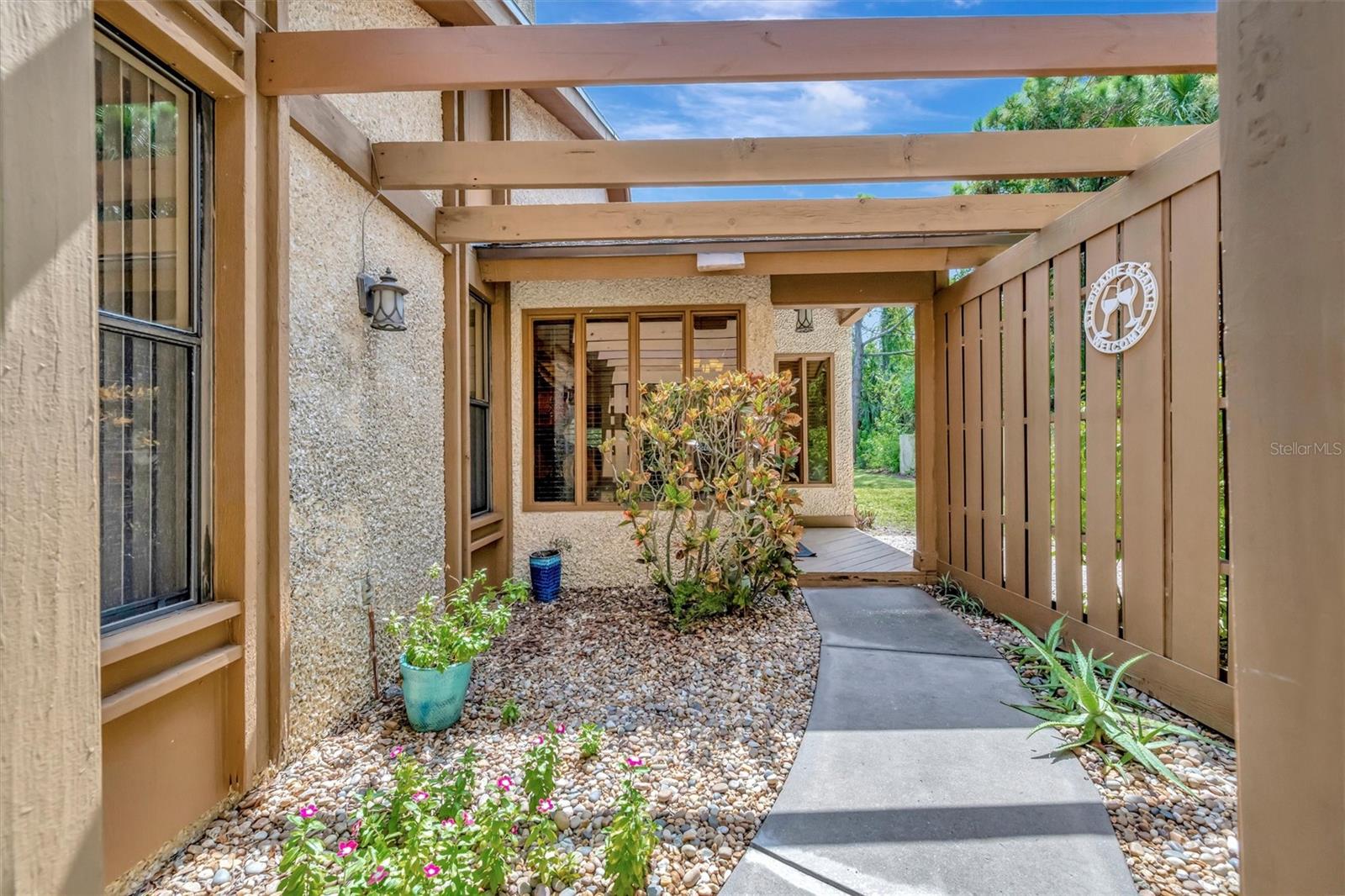 One or more photo(s) has been virtually staged. Welcome to this beautifully maintained 3-bedroom, 2-bathroom split-plan condominium in Pine Bay Forest offering 1,650 square feet of comfortable living in a prime location near the pristine beaches of Anna Maria Island. Step inside to discover high ceilings and a bright, open layout with tile and laminate flooring throughout. A cozy fireplace and wood accent details add warmth and character, while the large screened-in lanai provides the perfect space to relax or entertain year-round. The kitchen is both functional and stylish, featuring ample counter space and a layout that flows seamlessly into the dining and living areas—ideal for everyday living or hosting guests. The spacious primary suite features privacy from the guest bedrooms thanks to the thoughtful split-plan design. There's even a separate laundry room! Outside, enjoy lush, mature landscaping and access to fantastic community amenities including a sparkling pool and spa, tennis courts, and walking paths throughout. Whether you're looking for a full-time residence, vacation home, or investment property, this condo offers comfort, convenience, and coastal living at its best. Don't miss your opportunity—schedule your private showing today!