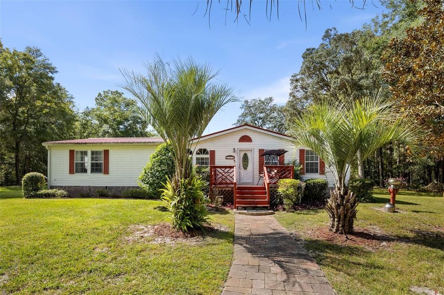 Welcome to your private, park-like retreat tucked away in peaceful Dunnellon. From the moment you arrive, you’ll fall in love with the manicured grounds, graceful palms, and the inviting front porch that instantly feels like home. Inside, a bright and welcoming layout offers a spacious kitchen with stainless steel appliances, custom wood cabinetry, and ample storage. The open living and dining areas flow seamlessly to an expansive screened-in back porch—perfect for morning coffee or evening gatherings overlooking the lush, beautifully maintained backyard. Pride of ownership shows in every detail, inside and out.

Outdoors, enjoy a charming paver patio with fire pit surrounded by mature trees and open green space. A massive detached, enclosed, and air-conditioned workshop/garage provides endless possibilities for hobbyists, storage, or business use, plus a covered carport behind it.

Need more space? The adjacent property is also available for $75,000, offering a combined 2.38 acres with a second 3-bed, 2-bath home—an ideal setup for multigenerational living, guests, or investment. The neighboring home is just under 2,000 sq. ft., has solid bones and a newer (˜5-year-old) roof, and simply needs some cosmetic updates to shine again.

Experience the tranquility of country living while staying just minutes from downtown Dunnellon, the Rainbow River, and all the amenities of Ocala.