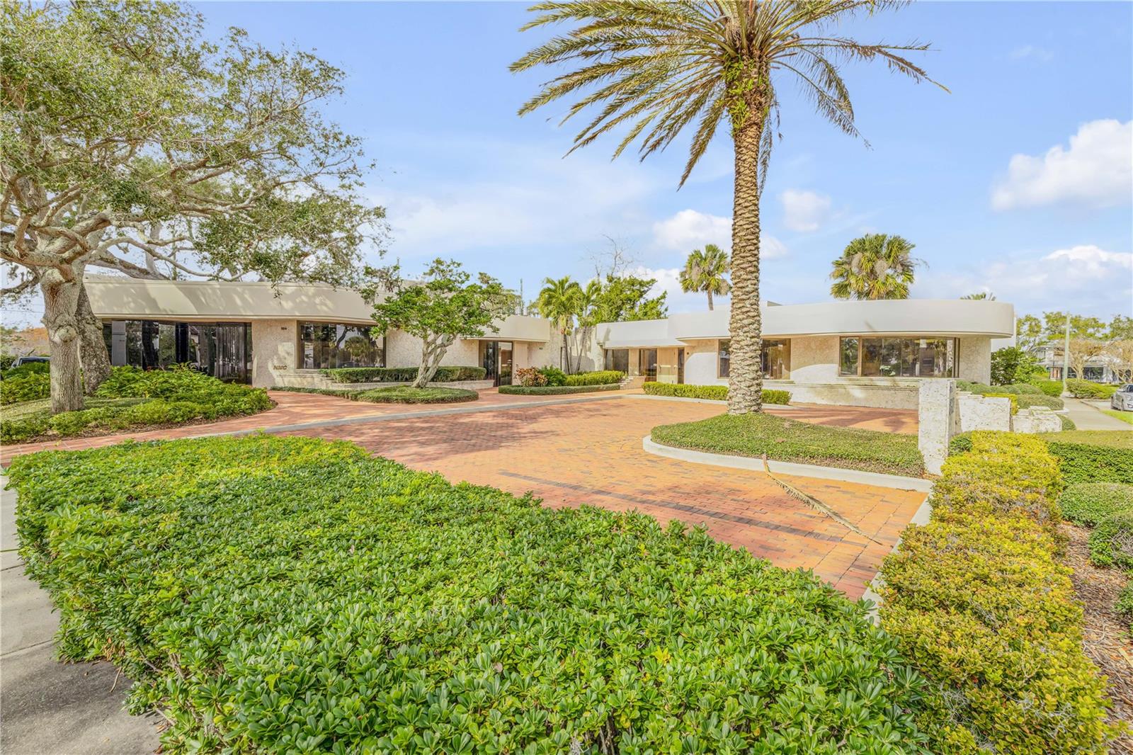 A Once-in-a-Lifetime Opportunity in the Heart of New Smyrna Beach, 104 South Riverside is on the market for the very first time.
This is your chance to own a true architectural masterpiece in one of the most coveted locations in New Smyrna Beach. Perfectly positioned across from the Brannon Center, this landmark property offers stunning water views from all three office units and commands attention at the corner of S Riverside Drive and Downing Street, with a private back alley leading directly to Canal Street. Zoned for mixed use, the opportunities here are boundless.
Designed by the renowned architect William Miller, who is celebrated for his free-flowing, innovative designs, this property is a rare work of art that cannot be replicated. Every detail has been carefully curated, from the layout to the finishes, creating a space that exudes sophistication and functionality.
Each office unit offers versatility, with the option to remain separate or seamlessly combine through adjoining walls to form one expansive space. The main office, designed with a commanding presence in mind, showcases heightened ceilings, custom doors, a vault room, and walls wrapped in premium mahogany wood paneling sourced exclusively from Honduras. The deeper tones and elevated finishes make this space ideal for leadership. The second office is thoughtfully designed for executives, featuring a lighter brighter feel with cypress wood paneling, locally milled and multiple private workspaces, a conference room, and a welcoming lobby bathed in natural light from custom sun tunnels. These architectural features including the Indigenous keystone flowing in and out, create a calm and inviting atmosphere, even during rainy days. The third office is an open, free-flowing space with expansive windows overlooking Manatee Park and the Brannon Center, offering inspiring views that energize creativity and productivity.
This property’s flexibility is unmatched. Operate it as a turn-key commercial space, reimagine it with commercial uses below and residential living above, or transform it into a luxurious all-residential retreat. The possibilities are as expansive as your vision. A 997-square-foot canopy provides convenient access from the back alley, allowing owners and visitors to enter without utilizing the main parking lot. With 11+ parking spaces between the rear and front lots, accommodating clients and employees is effortless. AC units were replaced in 2023 and a solid concrete roof was done in construction, to ensure long-term durability and peace of mind.
This extraordinary property offers a rare combination of iconic architecture, prime location, and endless potential. Don’t miss the opportunity to claim this one-of-a-kind landmark and create your legacy in New Smyrna Beach.