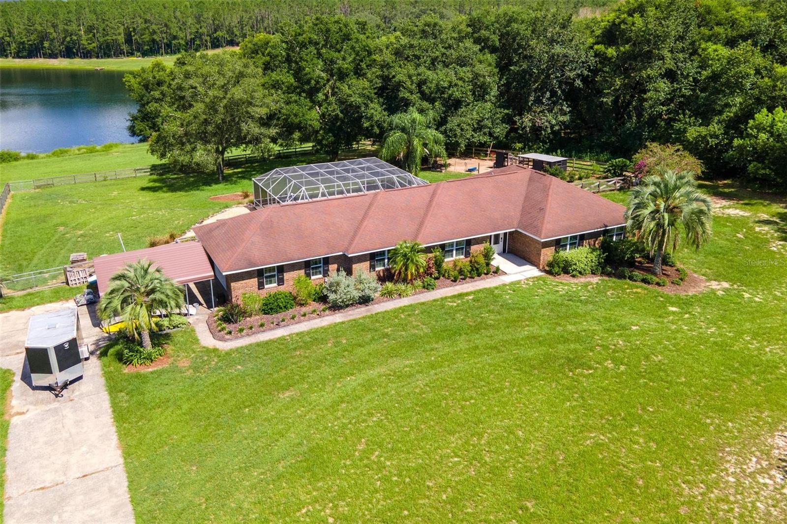 This home has all that you want and more!! Situated on over 3 acres on a spring fed lake, this 4 bedroom 2.5 bath home that has been remodeled can now be yours! From the moment you pull into the driveway, you will feel peace and serenity! Upon entering through the front door you will love the laminate flooring throughout and the fireplace in the living room. As you make your way to the large kitchen, the stunning new cabinets and countertops will WOW you! This kitchen includes all new appliances, soft close cabinets, granite counters and eat in space all overlooking your pool and lake. The dining room features a tray ceiling. Oversize primary suite as well as large additional bedrooms. An awesome plus is the new spray foam attic insulation which helps cut down on your electric bill. Imagine those hot Florida afternoons relaxing in your new screened in pool or on a chilly fall evening relaxing around the firepit area. Bring your chickens-a chicken coop is already on the property and do not forget your fishing poles! NO HOA! Convenient location to both The Villages and Umatilla. You do not want to miss the opportunity at this one! Call today to see before it is gone!