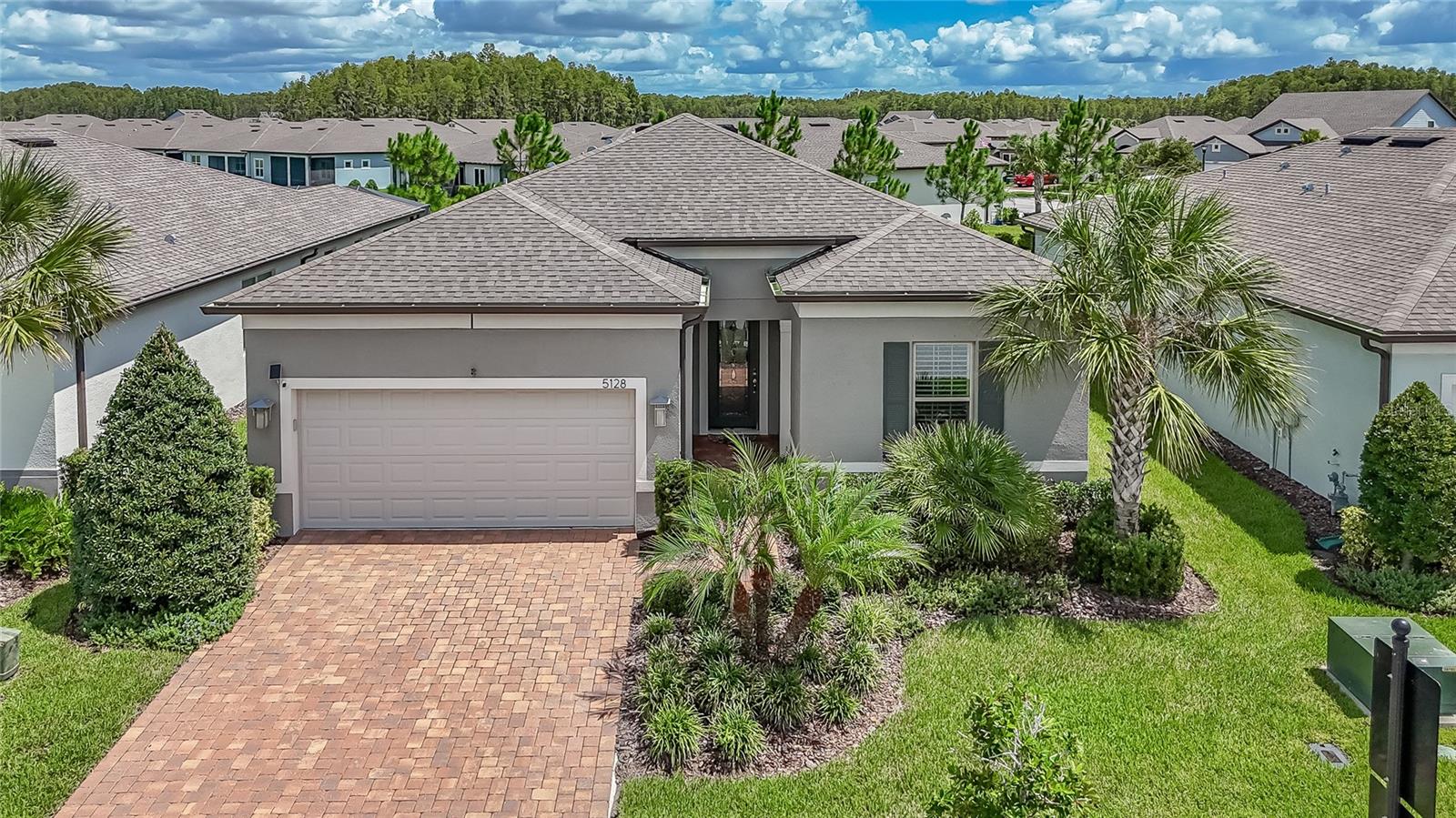 ABSOLUTELY NOTHING TO DO BUT MOVE RIGHT IN! This stunning 3-Bedroom, 2-Bath home with a FLEX ROOM is the ever-popular Summerwood floorplan, built in 2021, and LOVINGLY CARED FOR for by its owner. From the moment you arrive, the BRICK PAVER DRIVEWAY & elegant GLASS-INLAY FRONT DOOR door set the stage for the exceptional craftsmanship you’ll find inside. Step into the welcoming foyer and immediately notice the EXQUISITE CUSTOM WOODWORKING—a theme carried throughout the home and even showcased in the flex room & dinette, creating truly one-of-a-kind spaces. The UPGRADES HERE ARE ENDLESS. CROWN MOLDING graces every single room—including the bathrooms and laundry—while rich CERAMIC TILE FLOORING that looks like wood runs throughout the home. Not only does this eliminate carpet for easy cleaning & allergen-free living, but it also adds a sleek, high-end look. PLANTATION SHUTTERS on every window & the sliding glass doors add privacy, beauty, & timeless appeal. For peace of mind, the home also includes three OUTDOOR CAMERAS & a SECURITY SYSTEM. The heart of the home is the expansive GREAT ROOM with a striking COFFERED CEILING & built-in SURROUND SOUND SPEAKERS—perfect for relaxing nights in or entertaining guests. The dining area & breakfast bar are enhanced by gorgeous CUSTOM LIGHTING fixtures, adding warmth and elegance. The gourmet kitchen is a showstopper with top-of-the-line KITCHENAID appliances (all included), QUARTZ COUNTERS, a large CENTER ISLAND with sink & BREAKFAST BAR, GAS COOKTOP, WALK-IN PANTRY, & convenient PULL-OUT SHELVING. Whether hosting or cooking for two, this space is designed to impress. The primary suite offers a serene retreat with a vanity featuring two sinks, a large walk-in shower, space for a makeup table, & built-in CALIFORNIA CLOSETS. Custom wood closets don’t just look beautiful—they maximize organization & efficiency, giving everything a place. Two additional bedrooms provide comfort for guests or family, while the versatile flex room is ready to be your music room, office, sewing space, grandkids’ playroom, or whatever best fits your lifestyle. Step outside to the oversized SCREENED LANAI overlooking a peaceful PARTIAL POND VIEW. It’s the ideal spot for morning coffee, outdoor dining, or simply enjoying Florida’s sunshine & fresh air. Even the GARAGE has been upgraded with EPOXY FLOORS, and with a CENTRAL VACUUM SYSTEM, cleaning is quick and effortless—making this home truly move-in ready from top to bottom. Living here means more than just a beautiful home—it’s a lifestyle. Located in the gated 55+ community of Del Webb Bexley, your LAWN CARE IS INCLUDED, giving you more time to enjoy life. A full-time LIFESTYLE DIRECTOR ensures there’s always something happening, from FITNESS CLASSES and happy hours to food trucks, game nights, and SOCIAL EVENTS. The RESORT-STYLE AMENITIES include a Clubhouse, Pool and Spa, Resistance Pool, Fitness Center, Pickleball and Tennis courts, Dog park, Community garden, & over 35 CLUBS TO JOIN. Whether you want to stay active or simply relax, the choice is yours. With an unbeatable location less than 30 MINUTES to TAMPA INTERNATIONAL AIRPORT & DOWNTOWN TAMPA, and close to SHOPPING, RESTAURANTS, MAJOR ROADS, and top MEDICAL FACILITIES, this home is perfect as a full-time residence or a part-time escape from northern winters. This home exudes pride of ownership, offers UNMATCHED UPGRADES, & requires absolutely nothing....just bring your suitcase....and live the lifestyle you deserve!