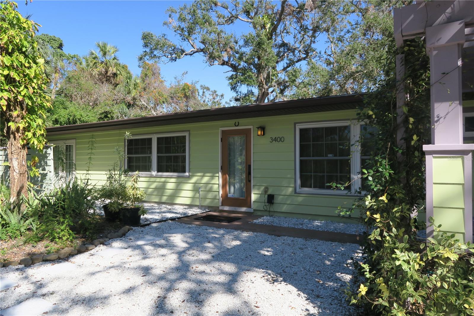 Discover this remodeled mid-century home located in the historic North Riverside Park neighborhood near downtown Sarasota. This charming home features a fully stocked kitchen with ample storage and stainless-steel appliances so much more. Unwind to the primary suite and exit to a patio area with a private outdoor shower. The den easily converts to a third bedroom for an occasional visitor and has a private patio space with tropical views of the garden. This indoor/ outdoor space is a true living experience.
Tucked away on a peaceful street, this home sits on an expansive double lot, offering a private oasis. Enjoy the picnic area with multiple seating areas, from the side patio to the spacious backyard garden, providing the perfect setting. Whether you’re relaxing in the lush outdoor spaces or unwinding inside, there’s no shortage of comfort here. As an added bonus, the property includes a finished air-conditioned shed one can use as a retreat—ideal for a quiet workspace or whatever your preference.
Enjoy the conveniences of nearby amenities and restaurants. If you love the beach, in just under 15 minutes or less you could enjoy the soft sands at one of two of the most popular beaches in the world. Come and experience the perfect blend of style, space and location.