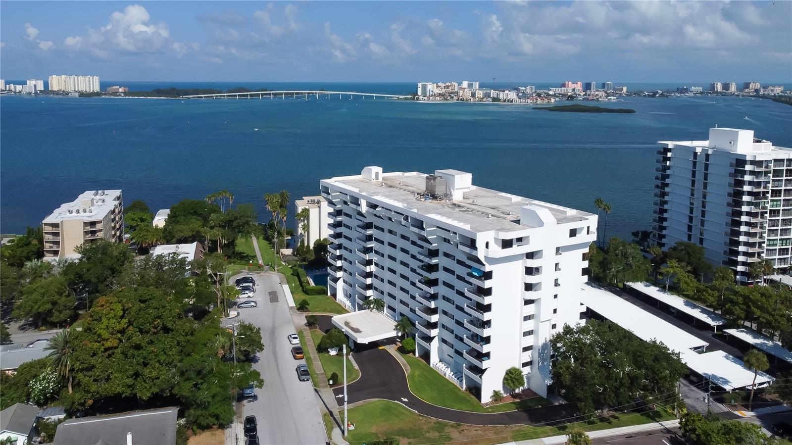 The best of two worlds converge into a perfect and vibrant 55 plus lifestyle right here at 30 Turner St. Built to stand the test of time, this block and steel constructed fortress caters to the beach life but was built on high ground and architecturally designed to redirect wind while maximizing the incredible views of Clearwater Beach and the Intracoastal Waterway. This sprawling 2nd floor northwest facing unit has been meticulously updated just one year ago and is adorned with a brand new open concept kitchen and luxury vinyl plank flooring throughout. Floor to ceiling sliders guide you out to your expansive balcony with breathtaking views of Clearwater Harbor and the Clearwater Memorial Causeway. The dining and living room flow effortlessly and are accompanied by high ceilings, fresh interior paint, and high end lighting. The Primary bedroom is awe inspiring with serene water views, spacious walk-in closet, and en-suite bathroom. Down the hall from the Primary is a modern half bath for guests. Multiple closets, cabinetry and a large first floor dedicated locker for gear offer additional storage. A dedicated covered carport and ample guest parking are sure to please. Elevators and a convenient washer and dryer room are just down the hall from the unit. The main level of the building offers resort style amenities with fitness center, heated pool, library, billiards room, banquet room, and restrooms. The affordable HOA payment includes water, sewer, trash, pool, maintenance, security, insurance on the building, basic cable, internet, exterior landscaping, and pest control. The heated swimming pool and loungers offer both relaxation and rejuvenation. A community park is just outside and is the ideal place to take your pets, get your steps in, or soak in the natural vitamin D. The park also has a large fishing pier and fish cleaning station situated right on the Intracoastal. Head down to watch jaw dropping sunsets and watch the pirate ship and dolphin tour boats pass by. This complex is pet friendly allowing up to two pets at or under 20lbs each. The location is a can't miss as you are surrounded by wonderful shopping plazas, public transit, local seafood, and is just across the bridge from world famous Clearwater Beach with its stunning turquoise waters and powder sand beaches. This is a unit and opportunity that truly sells itself and seeks a new owner to fill it with continued love and new memories. Flip flops and sunscreen required!