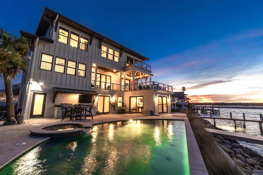 Introducing a Coastal Masterpiece: A 4-bedroom luxury haven, perfectly situated at the convergence of the Atlantic Ocean, Matanzas Inlet, and the Intracoastal Waterway. This architectural gem, completed just three years ago, spans over 5100 square feet, embodying the epitome of waterfront opulence.  Step into a world where water views embrace you from every angle. The first floor is a guest's retreat with a bedroom, full bath, and a game room overlooking the sparkling heated pool and spa. The garage, laundry room, exercise room, and a convenient pool bath are seamlessly integrated into this level. An elevator transports you to the second floor, unveiling an owner's suite and an open-concept kitchen, dining area, and living room. A fireplace, two sets of sliders to the expansive balcony, and a kitchen designed for entertaining make this level a true sanctuary. Marvel at the kitchen's grandeur, featuring the largest refrigerator imaginable, an expansive walk-in pantry, and a gas range offering wide open views where you can catch an occasional dolphin show while you prepare dinner. The third floor unveils a second owners' suite, an additional guest bedroom, and an office that opens to a loft with a balcony, providing an unrivaled vantage point for breathtaking sunsets over the Matanzas Inlet.  Outdoors, a deep-water dock with composite decking, a 10,000 lb boat lift, and a kayak dock are perfect for fishing enthusiasts or adventures on the water. You might even spy a manatee feeding on the Spartina Grass! Take a dip in the heated 36’ long pool or soak in the spa while your partner prepares dinner at the outdoor kitchen.  Then dine al fresco while the sun goes down over the water.  And it's easy to relax knowing this home has been built to the highest quality construction standards.  The first floor boasts concrete block construction, while the entire residence offers impact windows and sliders and a metal standing seam roof. Elevated 12 feet above sea level, this residence stands tall, ensuring luxury living at its finest in one of the most scenic spots in St. Augustine. Immerse yourself in the allure of coastal living and experience the pinnacle of sophistication in this unparalleled waterfront estate.