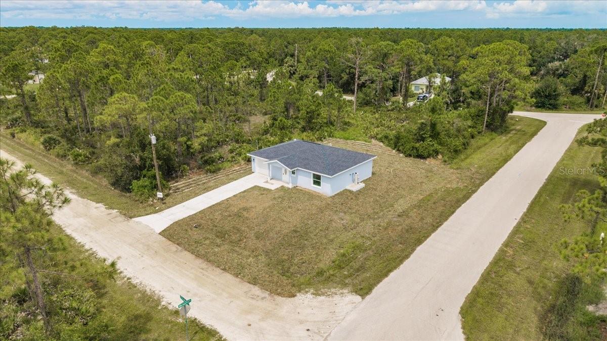 Skip the stress of building and move right into this brand-new 2-bedroom, 1-and-a-half-bathroom home with an attached garage, nestled in the peaceful rural community of Tropical Gulf Acres. Featuring an open-concept layout with a spacious great room, this home offers versatile living and entertaining space. Interior highlights include elegant wood-look luxury vinyl flooring throughout, tray ceilings in both the great room and primary bedroom, stylish light and ceiling fan fixtures, and recessed lighting for a modern touch. The kitchen is a standout with granite countertops, an abundance of shaker style cabinets, stainless steel appliances, a pantry, built-in buffet, and a breakfast bar that flows seamlessly into the great room—perfect for entertaining guests. The primary suite includes a built-in closet and a private full bath with a granite-topped vanity and linen storage. The guest bedroom also features a built-in closet. Additionally, a half bath in the hall adds to the practicality of the home. The property is further complemented by a single-car garage with ample space and a designated laundry area, providing the perfect combination of functionality and convenience. Hurricane impact windows throughout, provide enhanced storm protection, energy efficiency, and peace of mind year-round. Whether you're enjoying a quiet evening on the patio or entertaining friends in the open and inviting living space, this home is a haven of comfort and style. With its modern amenities, quality finishes, and the charm of being a single-owner property, this residence is ready to welcome its next chapter of memories. Located in a quiet, family-oriented neighborhood with no HOA or CDD. Minutes from historic downtown Punta Gorda, Fisherman's Village Restaurants, shopping, waterfront parks, events, and more. Close to I-75 and US-41. Near two airports: Punta Gorda and Southwest Florida International. Tropical Gulf Acres has a country-like feel, yet in a reasonable commute to Port Charlotte, Fort Myers, or Cape Coral.