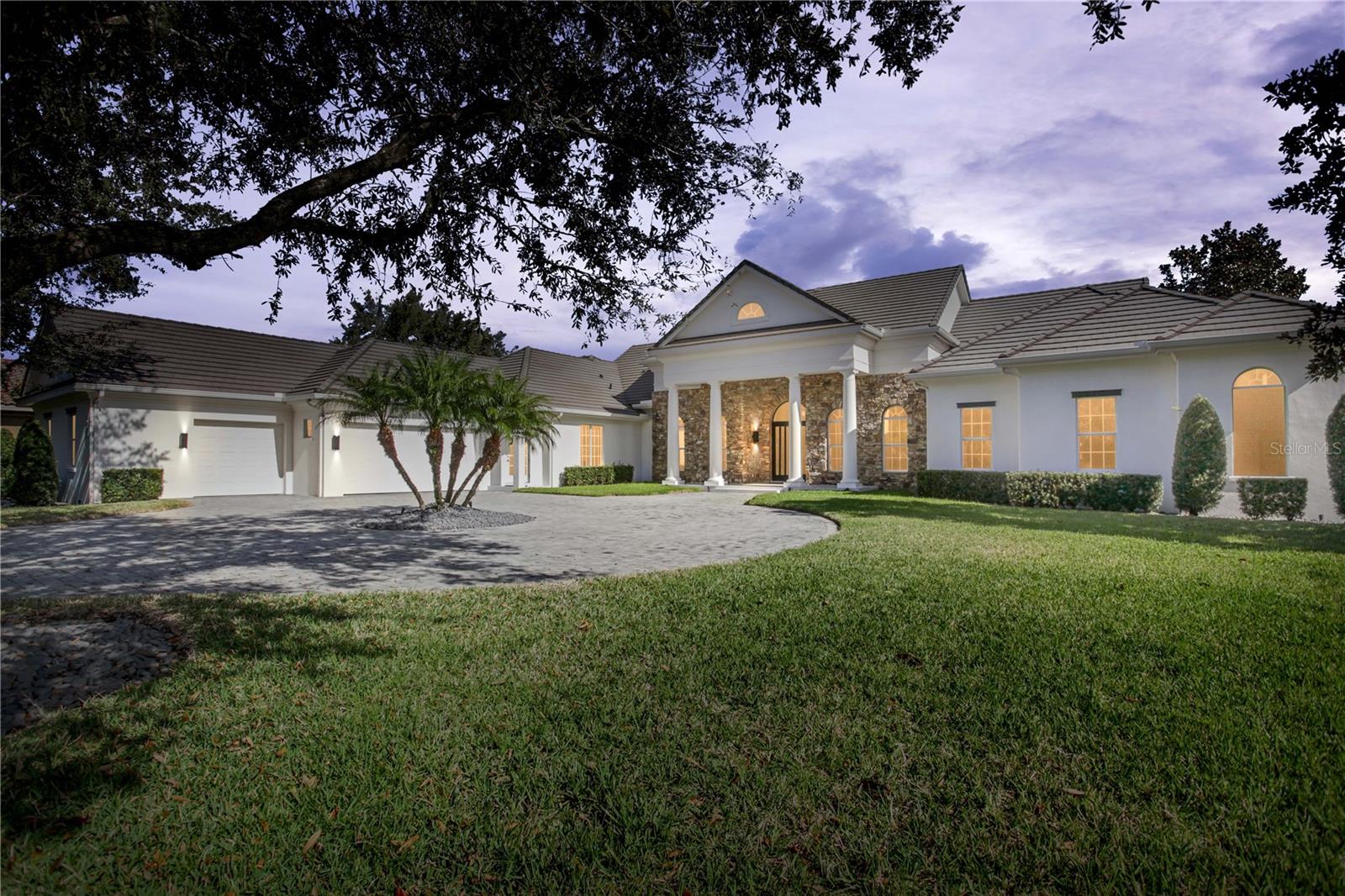 Follow a tree-lined drive to this private, transitional home offering four bedrooms, four full and one-half bathrooms. Throughout 5,094 square feet, this single-story residence reveals a pristine interior, with recent renovations, surrounding a beautiful outdoor living area and stunning water views. A grand outdoor living space greets you the moment you walk through the door. Tranquil water views and lush landscaping set the backdrop for the screened colonnade pool and spa. The covered lanai provides ample space for enjoyment. A fireplace, gazebo and summer kitchen complete this lavish outdoor area. The main living area of the home comprises the kitchen, family room, dining area and game room. Contemporary updates, including a stone accent wall and automatic shades, further accentuate this welcoming atmosphere. The gourmet kitchen offers an expansive island and bar, a built-in desk and an oversized walk-in pantry. Top-of-the-line appliances include a Bosch dishwasher, two Viking wine coolers, Dacor dual ovens, a pot filler and gas range. The master suite defines relaxation and features an expansive master bathroom centered on a Jacuzzi tub, a walk-through shower with multiple shower heads, dual walk-in closets, two vanities and an adjoining multi-purpose room. Three updated en suite bedrooms complete this elegant home. Additional features include an executive home office with murphy bed, mud room, generous laundry room and a three-car garage with exercise space and fully remodeled walk-in, temperature-controlled wine room.