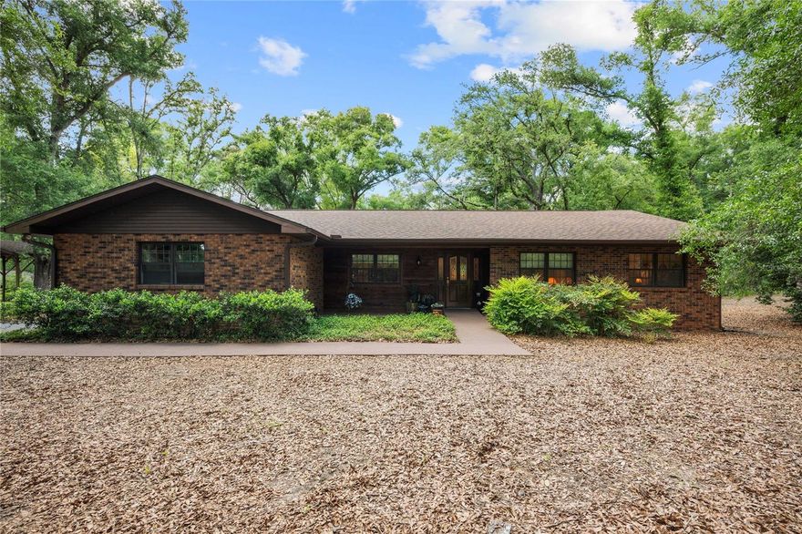 Welcome to 35935 Lana Drive in the highly sought-after Blanton area of Dade City, where peaceful country living meets timeless craftsmanship. This one-owner, custom-built home showcases true pride of ownership, constructed with a solid frame and brick exterior, elevated on concrete block pillars with a full block perimeter crawl-space. 
Thoughtfully updated, the home features a new shingle roof with gutters and screens, new skylights, double-pane Pella windows, a whole-house water softener, and a newly built wood deck extending from the screened-in back porch. It’s the perfect place for enjoying the serene surroundings.
Inside, you’ll find 3 bedrooms, 2.5 bathrooms, and a well-designed layout offering both formal and casual living spaces. The kitchen is equipped with a new dishwasher, downdraft range/oven, abundant counter space, and a custom-designed pantry that must be seen to be appreciated. A formal living room and dining room provide elegant entertaining options, while the spacious family room serves as the heart of the home, highlighted by a stunning custom gas fireplace, built-in shelving, cabinetry, and desk space. It’s ideal for both relaxing and displaying cherished pieces.
The primary suite offers ample room for a sitting area or home office and features a beautifully updated en-suite bath with a walk-in shower, granite countertops, and a custom-crafted walk-in closet.
Set on 2.5 picturesque acres, the property is truly special. It features mature, canopied oak trees, well-maintained landscaping, and a newer asphalt driveway that welcomes you home. For those needing additional space and functionality, the property includes a 24x20 workshop and an RV port complete with 50-amp and septic hookups.
Enjoy the beauty of rolling hills, privacy, and wide-open spaces while still being conveniently located near Dade City’s amenities and I-75. This is a rare opportunity to own a meticulously maintained home in one of the area’s most desirable rural settings.