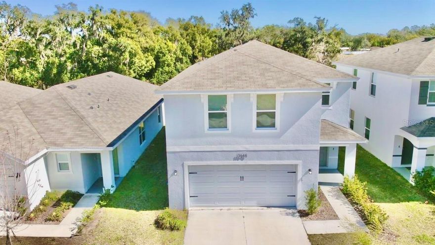 Don’t miss this move-in ready, 2023 built home featuring 4 bedrooms and 2.5 baths in one of Dade City’s most desirable communities. Impeccably maintained, this home offers a bright, open-concept layout ideal for modern living and entertaining.
Curb appeal shines with upgraded front lighting, refreshed house numbers, and new landscaping accented by a tropical palm tree. Inside, the living, dining, and kitchen areas flow seamlessly with abundant natural light and modern finishes. The kitchen is a standout, featuring crown-molded cabinetry, updated hardware, a stylish faux brick backsplash, and a contemporary dining light fixture. Upstairs, all four bedrooms are generously sized, providing comfort and privacy. A versatile loft adds flexible space for a home office, media room, or play area. Enjoy peaceful pond views and a spacious backyard perfect for relaxing or entertaining. Located just outside city limits, this home offers a quiet community setting while remaining minutes from downtown Dade City, schools, sports fields, and the fairgrounds. Nearly new and move-in ready—this is an opportunity you don’t want to miss.