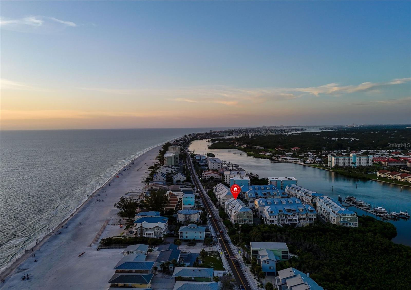 Turnkey luxury at Waterside Indian Shores with a rare beach facing corner unit. 19915 Gulf Boulevard #206 sits directly across the street from the sparkling Gulf of America in sought after Indian Shores. The newer construction 3-story townhouse includes 3 bedrooms plus a large top floor bonus room/loft currently used as a 4th bedroom featuring a private balcony with a view of the Gulf. Take the stairs or use the private elevator from the spacious and spotless tandem 3-car garage to access all three levels of living space. The home is truly a beach experience with a view of the Gulf from every floor as well as the garage level. Culinary enthusiasts will be thrilled with the luxury kitchen that includes a grand Cambria Quartz island, impressive lighted cabinetry, dedicated wine cooler and high end, sleek JennAir appliances, including gas cooktop for top performance. Those who are less enthusiastic about actually cooking will still love the area with its clean lines and plenty of space to gather. Gorgeous ceramic tile throughout the house adds to the flow and beauty of the living spaces. The home comes fully appointed with tasteful furnishings and decor perfect for a beach setting without overwhelming. The main floor is elevated with a roomy patio facing the Gulf, which is accessed by oversized sliders and has charming brickwork flooring complete with gracious outdoor living furniture. Back inside the main living area, soaring ceilings, large windows and thoughtful architectural flow make this space one that will bring joy to guests and homeowners alike. The second floor is dedicated to 3 bedrooms including the generous primary en suite. Bedrooms 2 and 3 share a jack and jill bathroom. All three are decorated in harmony with subtle furnishings that present the wonderful lightness and beach feel of this home. The laundry room is conveniently located on this floor and includes a high-end washer and dryer set. State of the art technology really sets this exceptional home apart: Sony Bravia Smart TVs in all rooms, surround sound speakers installed in multiple rooms for immersive audio experiences, Nest smart thermostats for energy efficiency and remote-control temperature all seamlessly controlled by a Control4 Whole-Home Automation System which also controls the lighting and security easily and smoothly. Also controlled by the automation system are the elegant Haiku ceiling fans in all rooms, 3-zone air conditioning system and motorized blackout shade in the living room for effortless privacy and light control. The location in the heart of beach town Indian Shores couldn't be more ideal. Just a quick few steps to beach access and the glorious Gulf, or steps to the Waterside shared pool which is also visible from the back of the home. Indian Shores is renowned for awe-inspiring beaches which are more peaceful than some of the touristy beaches on the barrier island. Centrally located on the island, Clearwater Beach is just an easy drive as is St. Petersburg with its charm and festive pier that hosts regular concerts and activities. This remarkable home is the complete package of opulence and beachy relaxation wrapped in one. Schedule your private showing today. Amazing sunsets await.