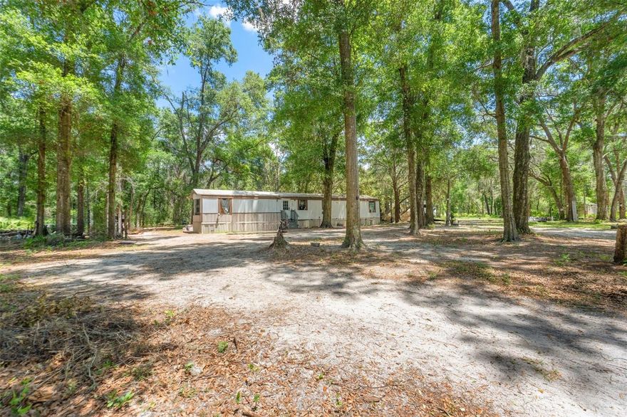 Located in the peaceful countryside of Dunnellon, this 1.25-acre agricultural property offers space, flexibility, and built-in income potential. The post-1976 2-bedroom, 2-bath manufactured home features 930 square feet with all utilities already in place, making it an easy move-in or investment opportunity. The home could be transformed into the perfect country retreat with a little love and updating, giving buyers the chance to add personal touches and build instant equity. Zoned agricultural and situated in Flood Zone X, the property invites you to bring your animals, toys, and outdoor lifestyle dreams without restriction. A rented RV positioned at the rear of the property currently provides passive income, adding immediate value for investors or buyers seeking supplemental cash flow. Surrounded by natural beauty and rural charm, the area is known for its wide-open spaces, riding trails, and proximity to the Rainbow River, offering kayaking, fishing, and year-round recreation just minutes away. Whether you’re looking for a homestead, rental property, or weekend retreat, this slice of Dunnellon country living delivers privacy, opportunity, and room to grow.