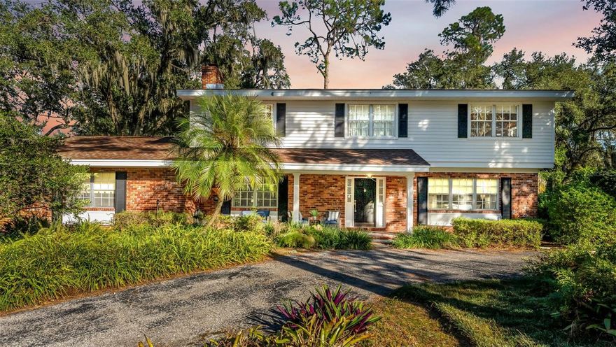 Discover a place where everyday living feels effortless and inviting.

Set on just under an acre in peaceful South Lakeland, this 4-bedroom, 3-bath home with a spacious bonus room provides plenty of room to play, grow, and unwind—inside and out. The brick two-story exterior, curved driveway, and cozy front patio create an immediate sense of comfort the moment you arrive.

Inside, thoughtful details unfold at every turn. A bright foyer with a generous double-door closet opens to a sunlit front room—an ideal spot for gathering, reading, or simply enjoying a quiet moment. French doors connect to the dining room, which flows easily into a warm, classic kitchen featuring natural wood cabinetry, a built-in desk, and a wide window overlooking the beautiful backyard. The breakfast nook is perfectly positioned to capture the morning light.

The living room brings rustic charm with shiplap walls, a brick wood-burning fireplace, and windows that fill the space with natural sunshine. A side door leads straight to the yard, making outdoor time effortless.

One of the home’s standout spaces is the large downstairs bonus room—complete with built-in shelving and a desk area—perfect for a playroom, creative zone, home office, or whatever suits your lifestyle. A full bathroom with a walk-in tiled shower and a well-appointed laundry room round out the first floor.

Upstairs, wood floors stretch throughout the sleeping spaces. The serene primary suite features a wide window alcove framed with glass shelving—made for curling up with a favorite book—and a generous walk-in closet with built-ins. Two additional bedrooms, each bright and comfortable, share a spacious bathroom with dual sinks and plenty of room to get ready.

Step outside to a backyard that feels like your own private retreat. With mature landscaping, wide-open green space, and nearly an acre to enjoy, there’s more than enough room for gardening, play sets, outdoor gatherings, or simply breathing in the quiet surroundings. The front patio adds even more charm, creating an inviting spot to relax any time of day.

Located near shopping, dining, and major routes, this South Lakeland gem blends privacy, space, and everyday convenience. Warm, welcoming, and full of character—this is the kind of place that feels like home the moment you walk through the door.