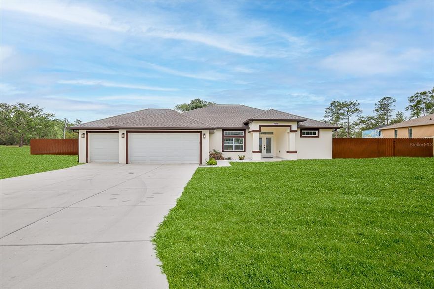 This is the one! Custom built in 2025 and rarely lived in, this home offers modern luxury, thoughtful design, 4 bedrooms, 2 bathrooms, a 3 car garage and over 3/4 of an acre of fenced property with stunning shade trees and room to enjoy both inside and out.
Enter through decorative dual-entry frosted glass front doors with a transom window above into an open, light-filled split floor plan featuring beautiful ceramic tile flooring throughout the entire home, designer lighting, and countless upscale touches.
The spacious great room offers a ceiling fan, designer fixtures, motorized window shades, and French doors leading to the covered lanai, creating seamless indoor-outdoor living. At the center of the home is the spectacular kitchen showcasing an impressive 8x5’ waterfall island with pendant lighting, sink, and extra storage. The kitchen also features wood cabinetry with soft-close doors and drawers, pull-outs and dividers, upgraded appliances including a convection oven with air fryer, pantry, breakfast nook, and dining area. Even the refrigerator is special, producing large round ice spheres.
This thoughtfully designed split-bedroom floor plan places three bedrooms on one side of the home, each with ceiling fans and electronic motorized window shades. One of the bedrooms is perfectly suited for a home office, hobby room, or flex space.
The guest bathroom is beautifully appointed with designer tile, a walk-in shower, rain head shower fixture, touch screen illuminated mirror, and stylish lighting. Multiple linen closets provide excellent storage throughout the home.
The luxurious main suite features French doors opening to the lanai, dual walk-in closets, and a dramatic spa-like bathroom complete with dual sink vanity, elegant flooring, a large walk-in shower with dual shower heads, linen closet, and a touch-screen illuminated mirror.
Additional upgrades and features include:
Instant hot water system 
Whole-house water filtration and water softener 
Gutters and downspouts
Electronic motorized shades 
Designer lighting throughout 
Laundry room with stainless utility sink 
Washer, Dryer
Double-pane windows tilt in for easy cleaning
Two garage door openers 
Three-car garage with direct backyard access and room for a workbench.   
Step outside to enjoy the covered lanai with tile flooring and two ceiling fans overlooking the expansive fully fenced backyard with aluminum fencing coated in vinyl and convenient side and front access gates. NO HOA so bring your toys, boats and RV's! Furniture available for sale separate from home sale. This exceptional property combines modern elegance, high-end upgrades, functionality, and privacy.