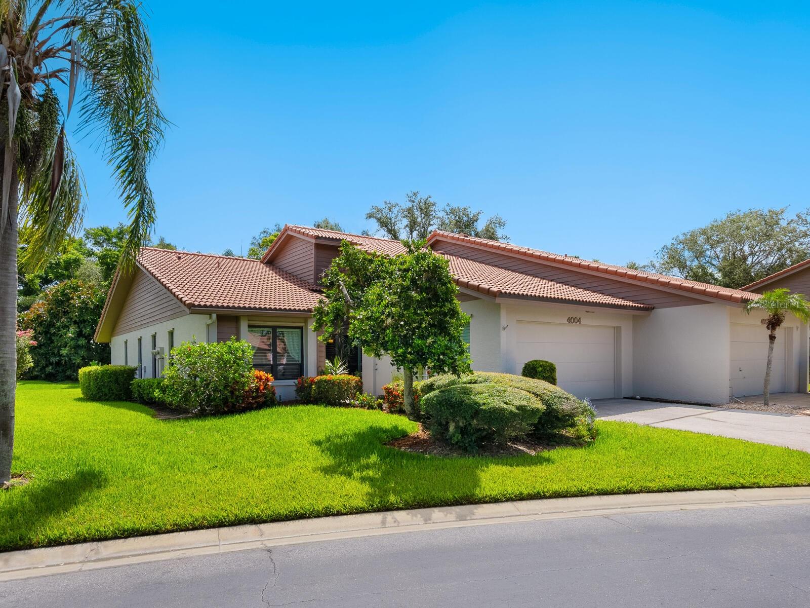 Welcome to your new home in one of Sarasota's most sought-after 55+ communities, offering resort-style amenities including clubhouse, tennis courts, pickleball courts, several serene lakes-all centrally located just minutes from shopping, dining, and a world class beach. Step inside to discover high-quality Cherry Bronze laminate flooring in the living and dining areas, giving the warm look and feel of hardwood. The vaulted ceiling in the rooms, enhanced by skylights, flood the space with natural light, creating a bright and airy atmosphere. Enjoy the expanded living area with a cozy Florida room, which was enclosed and tile floor raised, and impact-rated sliding glass doors installed showcasing peaceful views of a park-like backyard. The updated kitchen features wood cabinetry, granite countertops, stainless steel appliances, and a sunny eat-in nook. A large pass-through with granite ledge overlooking the dining room is ideal for entertaining and serving buffet-style meals. The spacious primary bedroom includes a charming nook, ideal for a quiet reading corner or small office. A large picture window frames the tranquil, private backyard, and a 5'X16' walk-in closet provides generous storage. The primary bath has been tastefully remodeled with new cabinetry, granite counters, and a walk-in shower with pebble type flooring. Additional features of the villa are Plantation shutters throughout(except Primary Bedroom), impact-rated windows and doors for peace of mind, electric hurricane shutter in the Florida Room, epoxy-coated garage floor, New AC in 2021, and hot water heater in 2025. The exterior of the villa was freshly painted in April 2025. This move-in ready villa combines modern updates and style in a maintenance-free community designed for active adults. Please note: this is a pet-free community.