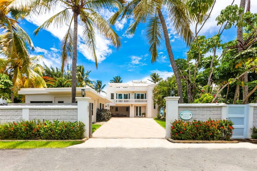 Paradise found in this oceanfront sanctuary, where contemporary elegance meets Caribbean charm. This 4,316 Sq. Ft. villa, set on a 1,017 Sq. Mt. lot, offers 8 bedrooms and 6.5 bathrooms, designed for those appreciate the essence of coastal living.

The main house: 
The first-floor features 2 bedrooms, living and dining area with a kitchenette, and a full bathroom. The living room opens directly to the patio and pool, offering easy access to the beach via a staircase. The second floor features 2 bedrooms, each with their private balconies, 2 full bathrooms, a fully equipped kitchen, and a bright living room with a balcony showcasing panoramic ocean views. The third floor provides a tranquil retreat with a bedroom, living room, full bathroom, and a large roof deck with a staircase from the oceanside balcony that descends to the beach, inviting you to relax in the turquoise waters or embark on a kayaking or paddleboarding adventure.
The property includes a separate guest house with 3 bedrooms, 2 full bathrooms, and two private entrances—one serving the 2-bedroom and the other for the 1-bedroom. This setup provides flexibility for extended family stays or rental opportunities, including its current use for Airbnb.

The property's design offers the option for private use or (4) four independent rentals, presenting an exceptional investment opportunity for both short-term and long-term stays.

This compound features a well-appointed outdoor kitchen, perfect for entertaining by the pool and jacuzzi. It also offers three covered terraces, carport, a 20 KW power generator, and a 500-gallon water cistern.

Located in the vibrant Río Grande area, this coastal haven is just 35-40 minutes from San Juan Airport. It’s a short drive from the renowned Río Mar Wyndham Resort, which offers a championship golf course and stunning beach. Nearby, the Kioskos de Luquillo provide a taste of exquisite local cuisine, while the El Yunque National Forest offers adventures amidst lush rainforests. Boating enthusiasts will appreciate the proximity to marinas, and attractions in Luquillo, Fajardo, Carolina, and San Juan are easily accessible.
