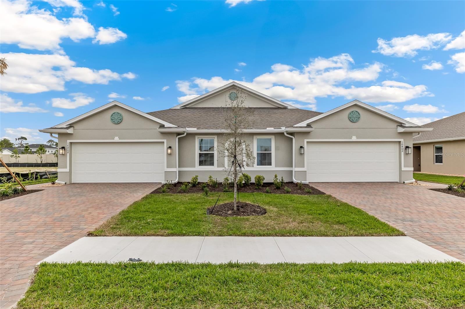 This stylish twin villa home in Cove at West Port features an open-concept design that makes gathering with friends and family a breeze. The well-appointed kitchen features a quartz countertop with ample space for preparing meals and a breakfast bar for eating. The kitchen seamlessly flows to the dining and living areas. Sliding glass doors open from the living room to the covered lanai extending the living space outdoors and providing the perfect place for relaxing or dining al fresco.
An expansive primary bedroom, situated at the back of the home for privacy, includes an en suite bathroom with double vanity and walk-in shower. The guest bedroom features a walk-in closet and is in close proximity to the second bathroom. A den with double doors can be utilized as a home office or cozy living area. A two-car garage and laundry room complete this home. Contact us today for more information or to schedule a tour of Cove at West Port.