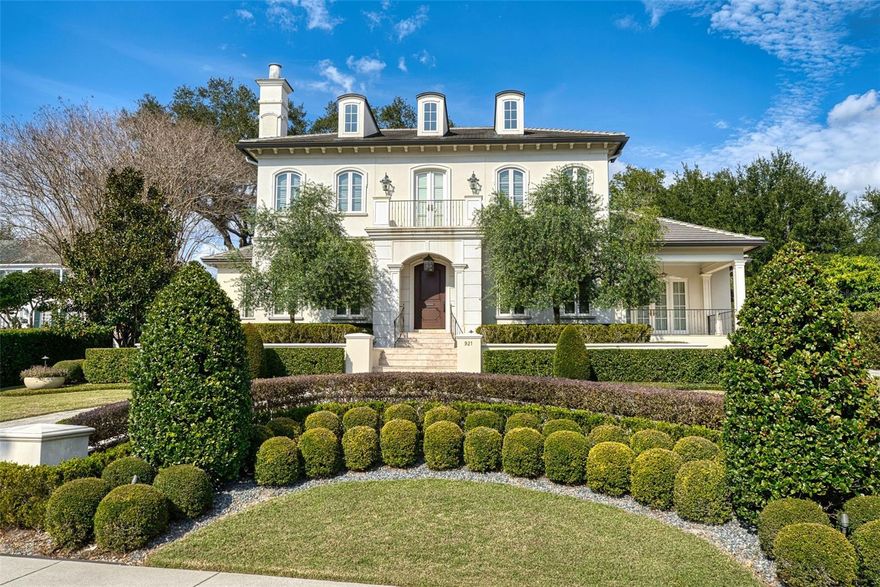 Distinguished estate residence overlooking Lake Adair in the heart of College Park. Built in 2015 by award-winning custom builder Goehring & Morgan, the home spans approximately .7 acres from N Lake Adair Boulevard to Oak Street and includes a private rear entrance. The thoughtfully designed floor plan features a main-level primary wing with two full bathrooms, two walk-in closets, and a study. Formal living and dining rooms are complemented by a large, well-appointed kitchen open to the family room, with French doors leading to a covered porch and private backyard. Upstairs includes three ensuite bedrooms, a sitting room with wet bar, and a bonus room above the garage. Architectural details include multiple fireplaces, hardwood floors, crown moulding, and custom built-ins throughout.