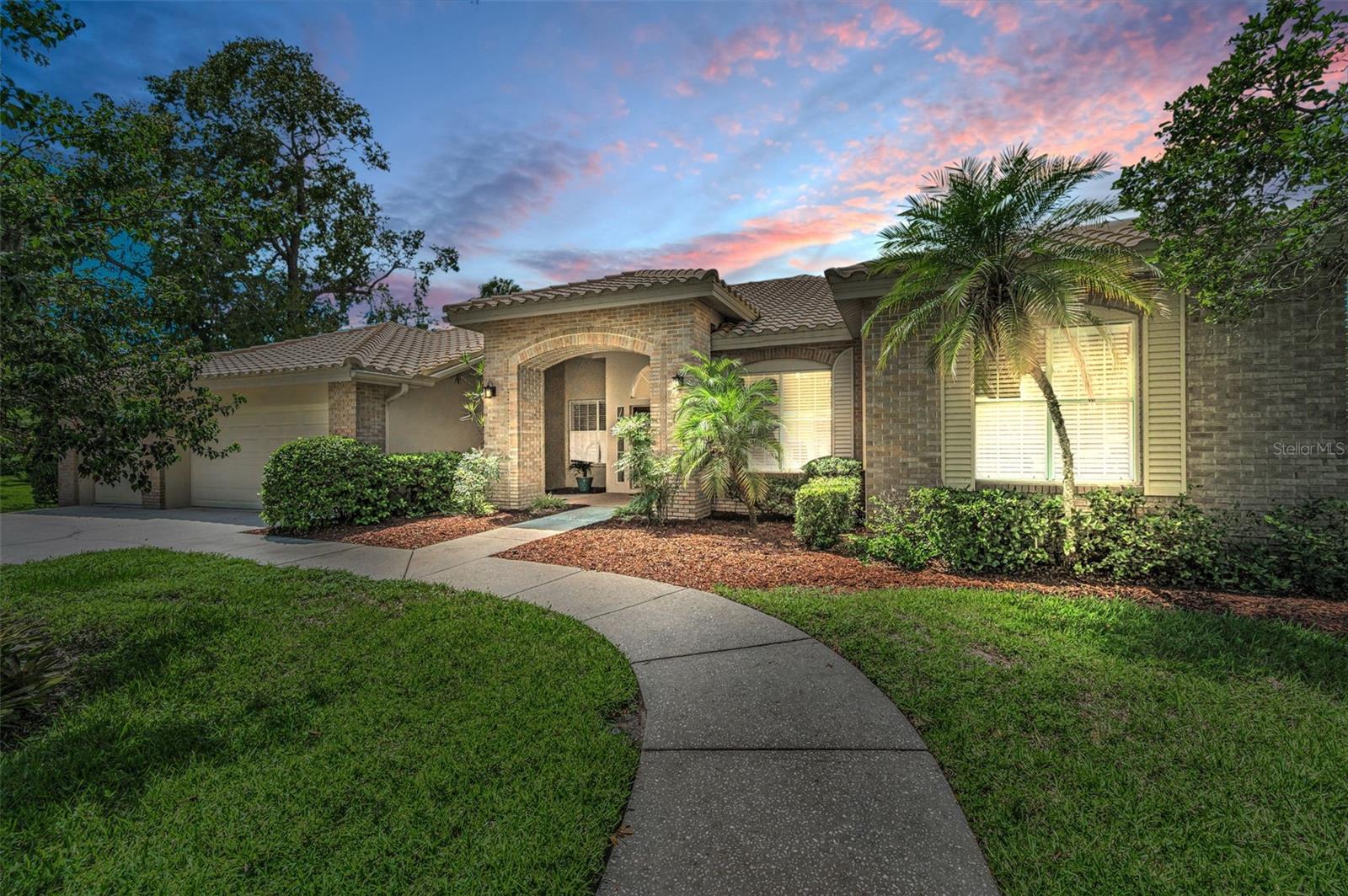 Spectacular Golf Course Living in Eastlake Woodlands!
Enjoy privacy, elegance, and breathtaking golf course views in this beautifully appointed 5-bedroom, 3-bath, 3-car garage home backing to the Ardea Country Club North Course Signature Hole #10 in the gated community of Eastlake Woodlands. A former model home, this residence welcomes you with a grand marble foyer and sweeping views of the golf course. Inside, you’ll find volume ceilings, fresh interior paint, and a spacious layout designed for both entertaining and everyday living. The gourmet kitchen features stainless steel appliances, an induction cooktop, impeccably maintained tile countertops, a large pantry, a center island and counter seating that opens to the gathering room and breakfast nook. The expansive gathering room offers soaring vaulted ceilings, an electric fireplace, wet bar, and wall of windows framing the serene backdrop. Step outside to your private outdoor oasis — an oversized pavered lanai with pool, spa, and panoramic screen enclosure — perfect for relaxing or entertaining. The luxurious primary suite boasts a sitting area, desk, custom walk-in closet, and en-suite bath with marble tile counters and floors, garden tub, walk-in shower and water closet for privacy. Additional highlights include a split bedroom layout, a versatile office/5th bedroom with French doors, built in features and updates including new garage doors (2018), conversion of fireplace (2024), and updated hall bathrooms. Located in the desirable Turtle Creek subdivision, this home is high and dry in a no-flood zone and sustained no storm damage. Eastlake Woodlands offers unmatched lifestyle amenities through membership at the newly remodeled Ardea Country Club, featuring championship golf, tennis, pickleball, swimming, fitness center, and more. All this, just minutes from top-rated schools, shopping, dining, award-winning beaches, and Tampa International Airport. Room sizes are approximate.
Don’t miss the 3-D tour and virtual tour with drone photography to experience the lifestyle this home offers!