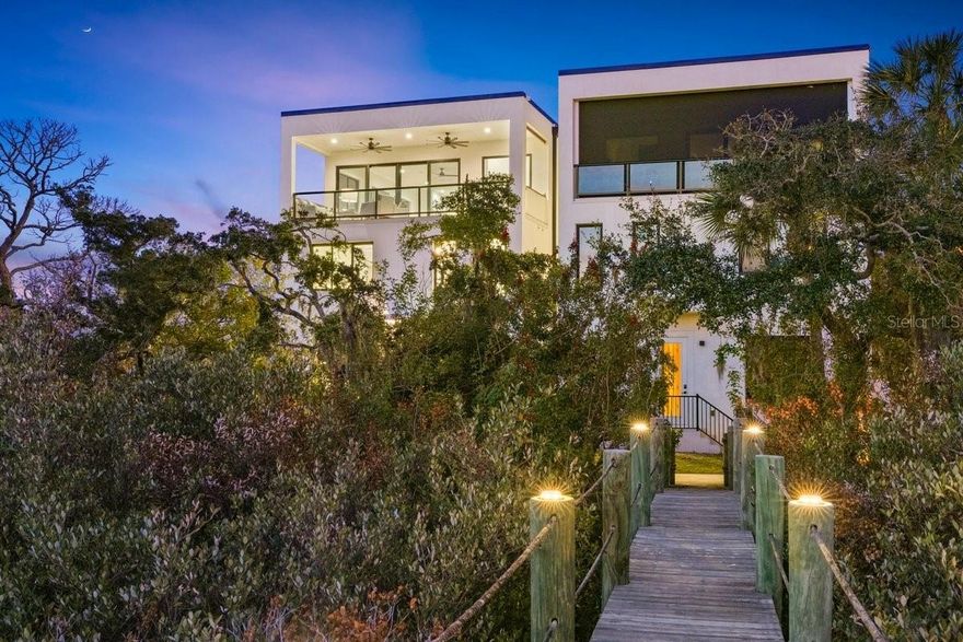 Waterfront living in New Smyrna Beach’s coveted Central Beachside district reaches a new level at 552 N Peninsula Avenue, a newly constructed 2024 modern residence positioned along the deep water Callalisa Canal/Creek with direct access to the Intracoastal Waterway. Designed for the avid boater, this exceptional property offers 3 deep water boat slips, including a 16,000 lb boat lift, allowing effortless access to the Intracoastal, Mosquito Lagoon, Ponce Inlet, waterfront restaurants, and the Atlantic Ocean right from your private dock. Located in the heart of Central Beachside New Smyrna Beach, the home also offers golf cart convenience to the beach, Publix, Flagler Avenue’s shops and restaurants, and nearby Smyrna Dunes Park. Spanning three stories with a private elevator, the residence showcases sleek modern architecture and over 3,700 square feet of coastal living, with panoramic water views from the third floor balcony, main living area, and designer kitchen. The home features 4 spacious bedrooms and 4 1/2 baths, with each bedroom designed as a private retreat complete with its own ensuite bath, offering both comfort and privacy for family and guests. The main living space is filled with natural light and flows seamlessly into a chef inspired modern kitchen, creating an inviting environment for entertaining while enjoying the tranquil waterfront setting. The first floor offers exceptional flexibility, making it ideal for a variety of lifestyles. A private suite on this level can easily function as an in-law suite, guest quarters, or a quiet home office, providing separation and privacy from the main living areas. The oversized laundry and utility room has been thoughtfully designed with boaters and anglers in mind, doubling as a fishing gear and rod storage area and featuring an ice machine, making it easy to prepare for a day on the water or return from an afternoon of fishing. Outdoor living is equally impressive, highlighted by an expansive third floor balcony with a fully equipped summer kitchen, offering the perfect vantage point for coastal breezes and beautiful sunsets over the canal.  Additional luxury features include a two car garage with generous storage, a commercial grade TPO roof with an estimated 15–20 year life expectancy, and an underground filtration system designed to collect and disperse watershed. The property carries a LOMAR designation, meaning flood insurance is not required, and it is located in Flood Zone X. Paver driveway and electric gate from the south of the property provide peace of mind. Perfectly positioned between the Intracoastal Waterway and the Atlantic Ocean, this exceptional residence blends modern design, luxury waterfront living, and the relaxed coastal lifestyle that makes New Smyrna Beach one of Florida’s most sought after destinations. This is more than a home, it is a rare deep water canal estate in one of New Smyrna Beach’s most desirable waterfront corridors. Buyers are encouraged to view the video tour.