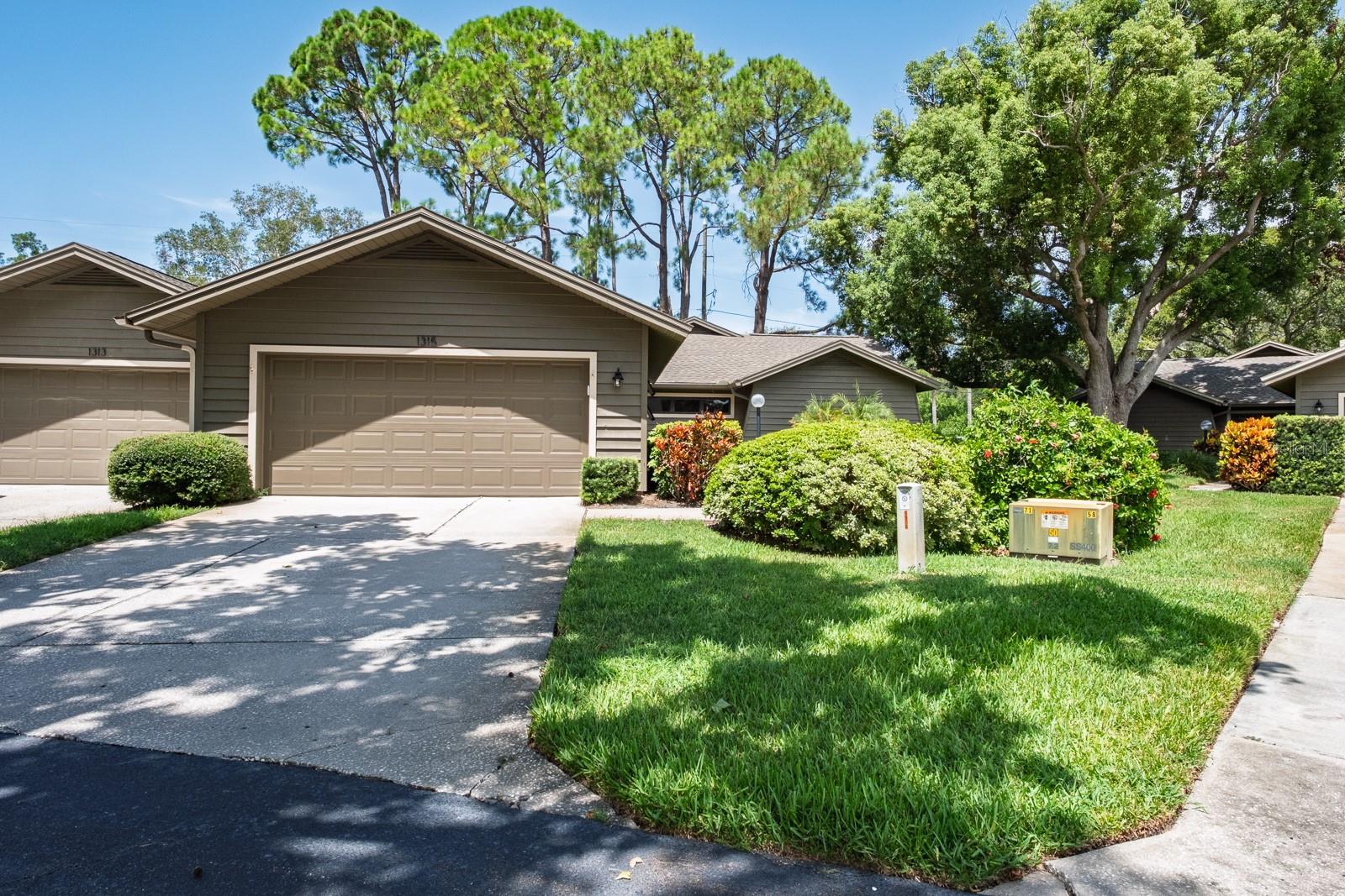 A rare find! Welcome to the magnificent sought after Westlake Villas Community! Maintenance free, luxury living in a fabulous location. This exceptional 2 bedroom, plus an office/den, 2 full baths, 2 car garage treasure is the perfect combination of style, comfort and convenience. Enter the well-maintained interior to be greeted by spacious living areas with natural light courtesy of an entryway skylight. The kitchen offers a lovely eat-in area, breakfast bar, ample cabinetry with pull-out shelving and newer stainless appliances including a built-in microwave, ceran top range and 4-door refrigerator. The breakfast area offers a charming bay window... and it is open to the grand living area. The sunken, stylish main living space is centered by a stone surround fireplace that offers design and ambiance. The floorplan offers a formal dining area and the bonus of an office/den with endless possibilities. The primary bedroom brings an immediate atmosphere of tranquility. Modern, spacious and boasting a soaring beamed ceiling and modern accent wall, a walk-in closet featuring a posh Bahama closet door, an ensuite bath with double sink vanity and walk-in shower. The second full bath is conveniently located near the generously sized 2nd bedroom while also accessible to guests. The bathroom features a newer vanity with a fashionable vessel sink and tub/shower combo boasting designer tilework. Living and entertaining space is extended to a 2-level screened patio space. Privacy prevails as you look out on serene oaks and professionally manicured grounds. Perfect for morning coffee or afternoon cocktails! Too many features to mention in this villa style condo in the rarely available community of Westlake Villas… generous sized laundry room with shelving and folding area, pull down attic stairs for extra storage, 2025 new water softener, oversized 2 car garage, wood accents and panels adding charm and style, so much to see! The community is nestled in desirable Palm Harbor near to shopping, restaurants, entertainment and the festivals and vibe of Old Palm Harbor, and of course the Gulf Beaches are nearby. HOA includes Spectrum internet, roof, exterior painting, grounds maintenance, outside pest control, water, sewer and trash. Magnificent community, pet friendly neighborhood, distinctive home… make it yours!