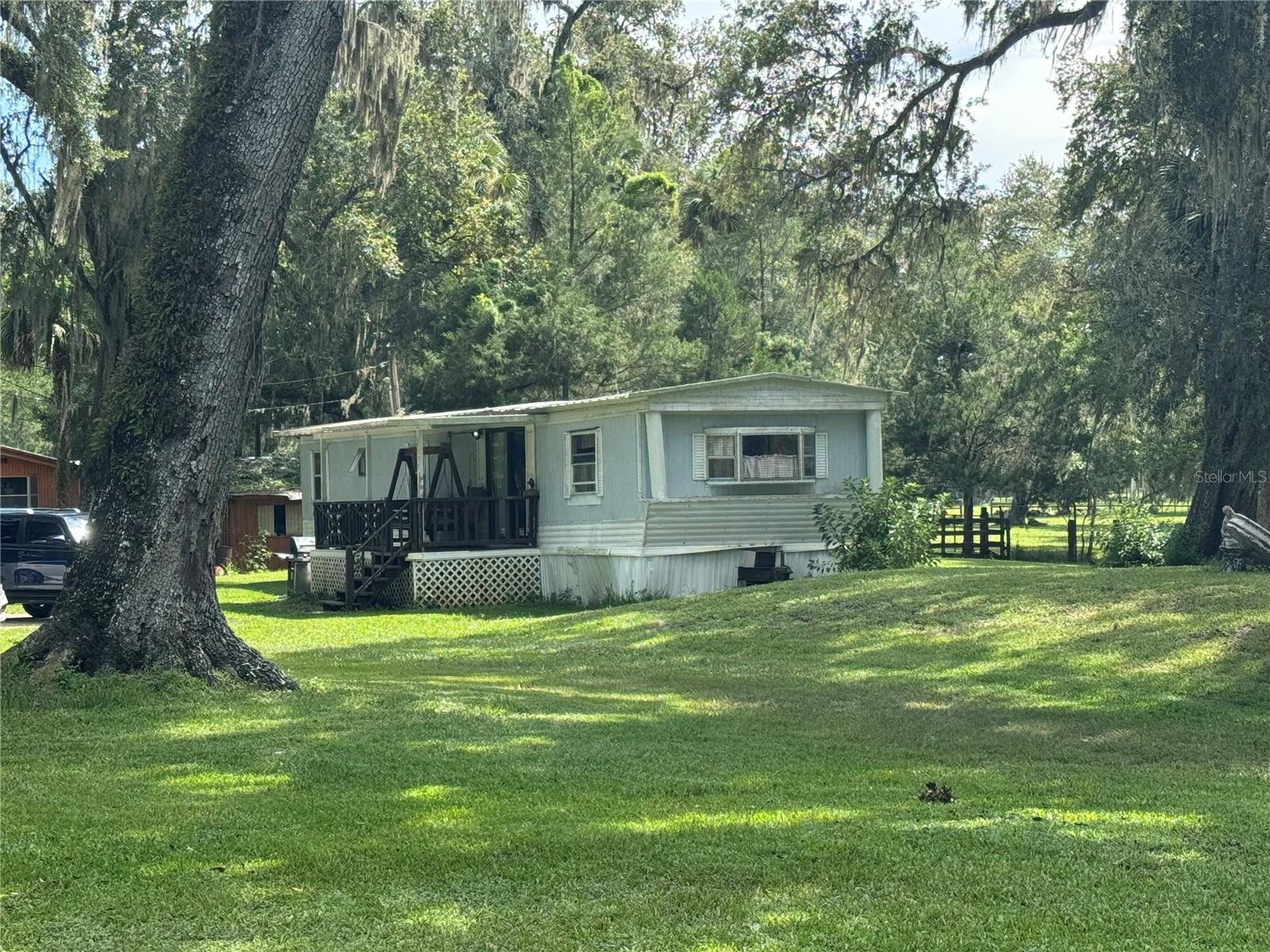 Great investment opportunity! 2 bedroom 1 bath mobile home on 2.1 acres. Includes polebarn shed with workshop. Paved road. No HOA or flood zone. Sold As Is. CASH only since it was built before 1976. An adjacent 4.5 acres is also available for $50k (OM707608 - TBD CR 423). Old boat with a motor is $50.