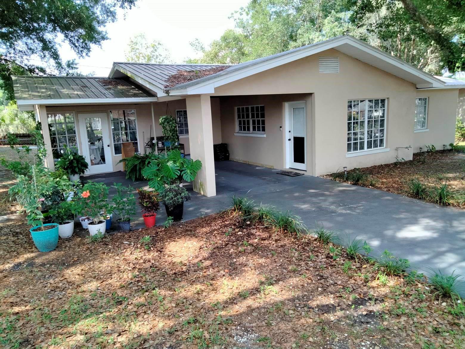 Under contract-accepting backup offers. Beautiful, shaded corner lot right in the heart of Zephyrhills. No HOA or CDD fees to pay! This home features custom, epoxy-finished concrete counter-tops with built in sink, custom backsplash, high end faucet, matching appliance set, & painted solid wood cabinetry. You'll appreciate relaxing in your back yard with a custom Tiki Hut with epoxied bar-top and electric. The bathroom/shower is 360 degree custom tiled with glass curtain & glass block. 2.5 ton Grandaire A/C system, approx 3 yrs & digital thermostat, laminate flooring in the living room & bedrooms and tile floors with stain-resistant grout everywhere else. Other features include solid block walls, large windows offering a variety of views, vanities, toilets, bidet(Master Suite), drywall & drop ceilings, texture, ceiling fans, windows, recessed LED cans, retro dining room lamp, GFCI, & dry erase board/TV wall niche in bedroom. Other exterior features include stucco, driveway/porch, solar garden lights and motion sensored porch lights, mailbox, porch, carport and metal-galvalume roof, approx under 8 years. Buyer/Buyer's agent to verify specifics during due diligence.